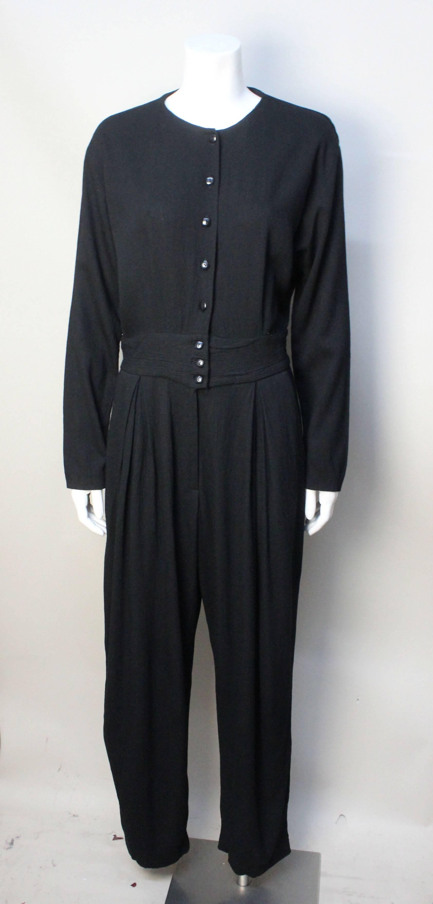 Geoffrey Beene found inspiration in everyday utilitarian clothing and uniforms. This jumpsuit appears to be based on a mechanics coverall, but styled in a feminine fashion. The fabric is a drapey rayon with a bit of lycra stretch to it. It has a