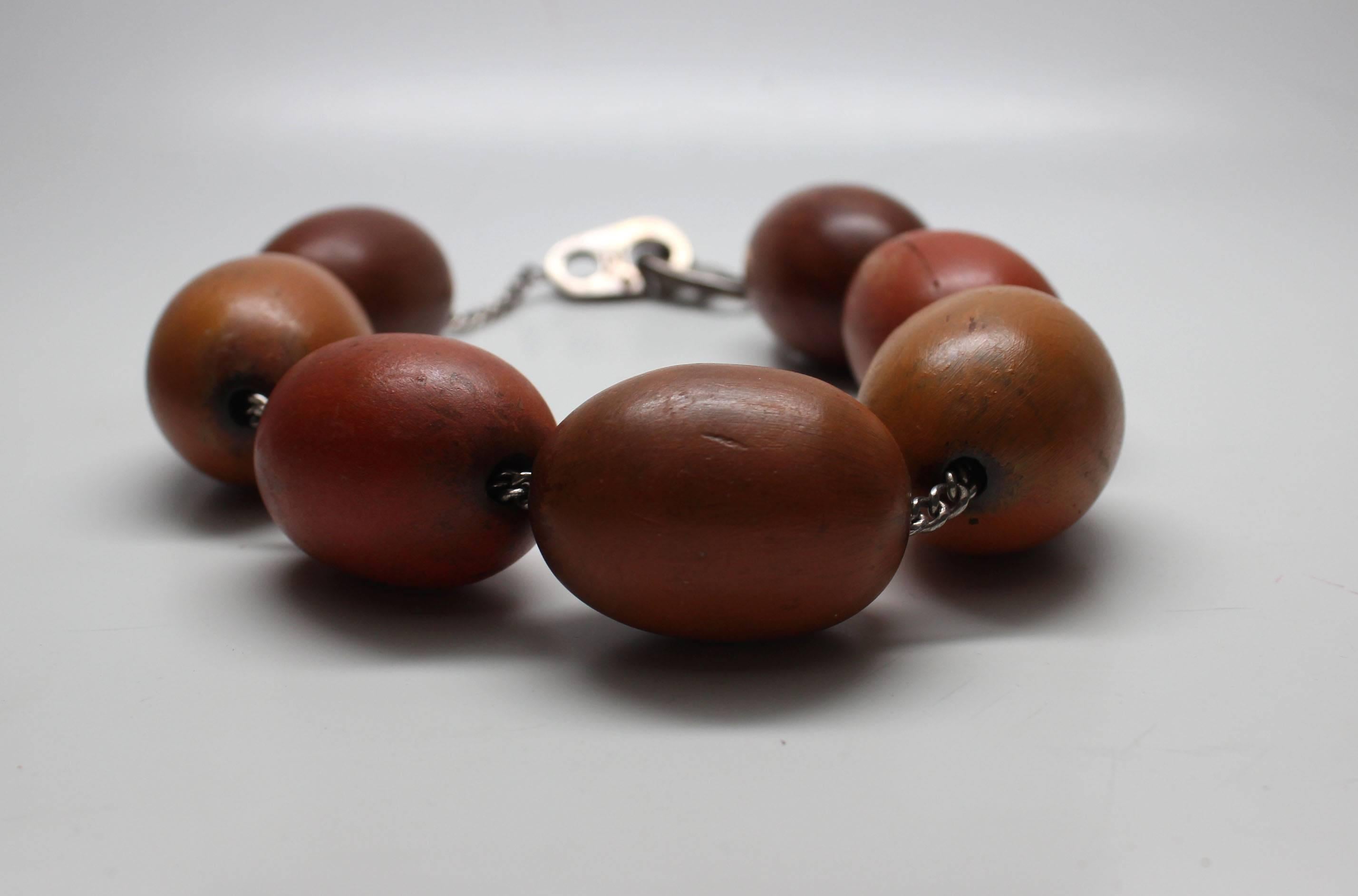 This statement necklace has 7 large polished egg shaped wood beads on a sterling chain with a sculptural sterling clasp.