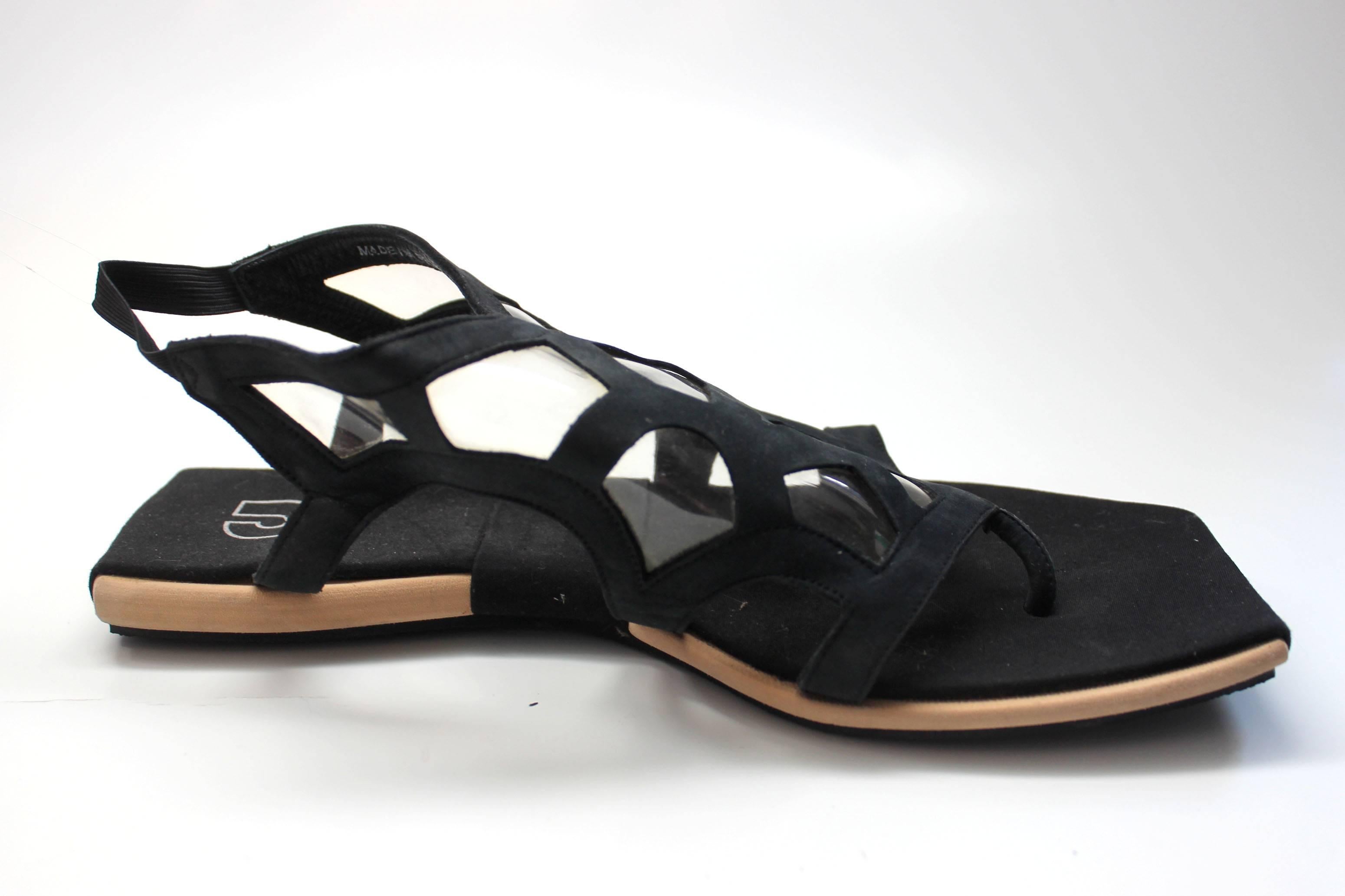 These sandals are uniquely designed and stitched. The uppers have inserts of see through vinyl incorporated into the black suede geometric pattern. The soles have an angular cut. They are in new, never worn condition and come in their original box. 
