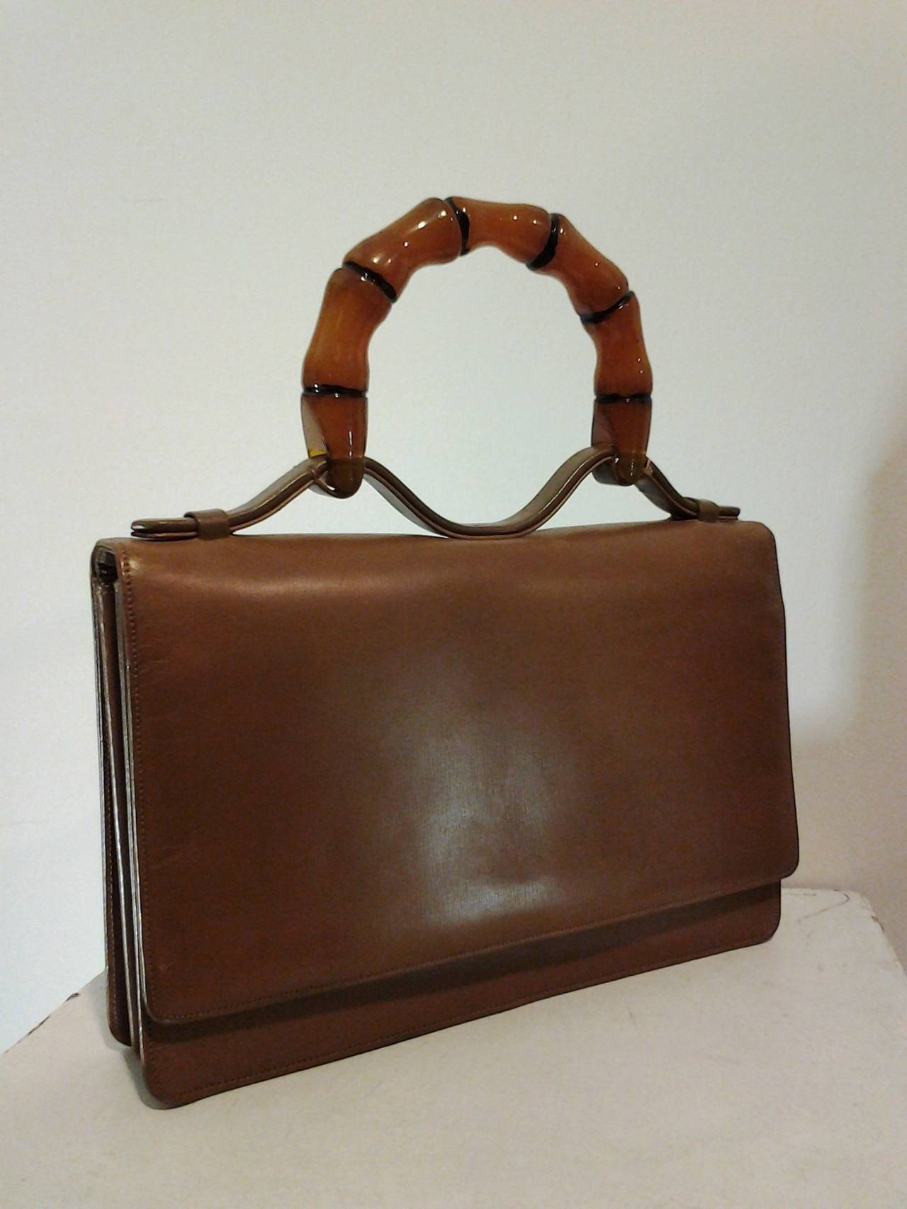 A fabulous and smart 1960s Harry Rosenfeld accordion style, camel colored leather handbag with stunning lucite faux bamboo handle,.