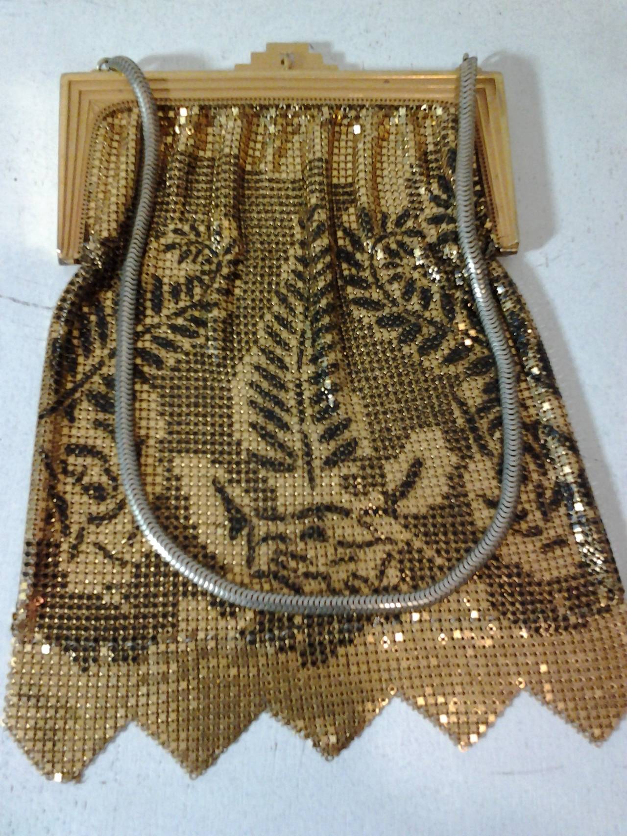 A stunning black and gold metal mesh 1920s evening bag (unlined) with black enamel rose and fern leaf pattern.  Chain link handle.
