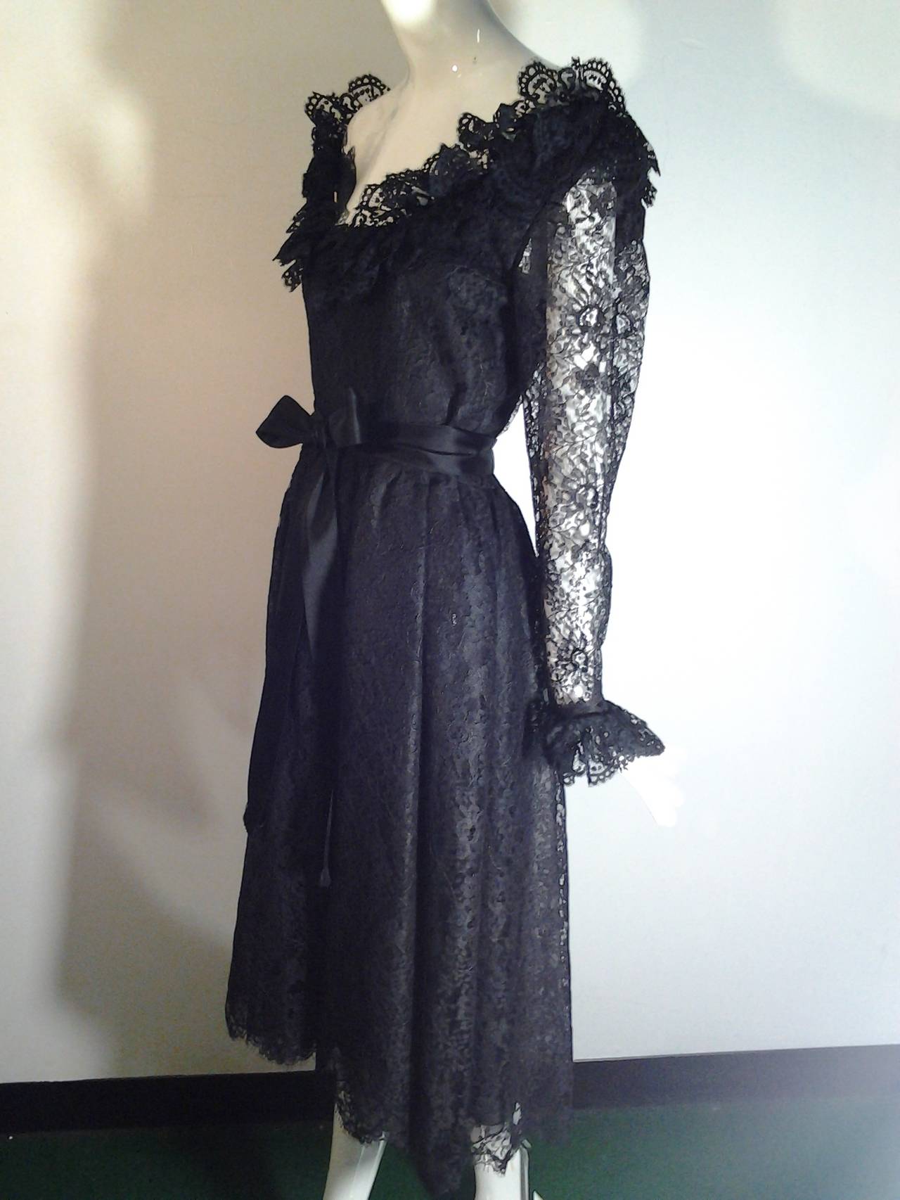 1970s Oscar de La Renta black lace illusion cocktail dress with sheer ruffle cuff sleeves, neckline and waist tie.  

3 layer lining in body of dress.