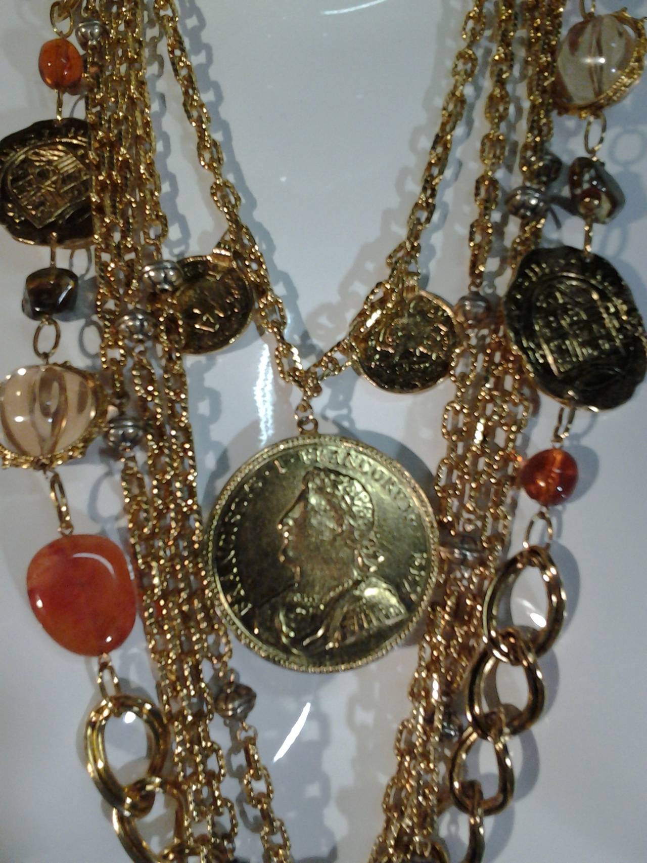 An exceptional and rare Les Barnard gold plated 5-strand necklace with copious coins, cross and lucite orbs.  Italian/Roman inspired coin motifs.  Substantial in weight and beautifully balanced. 

Shortest chain is 23