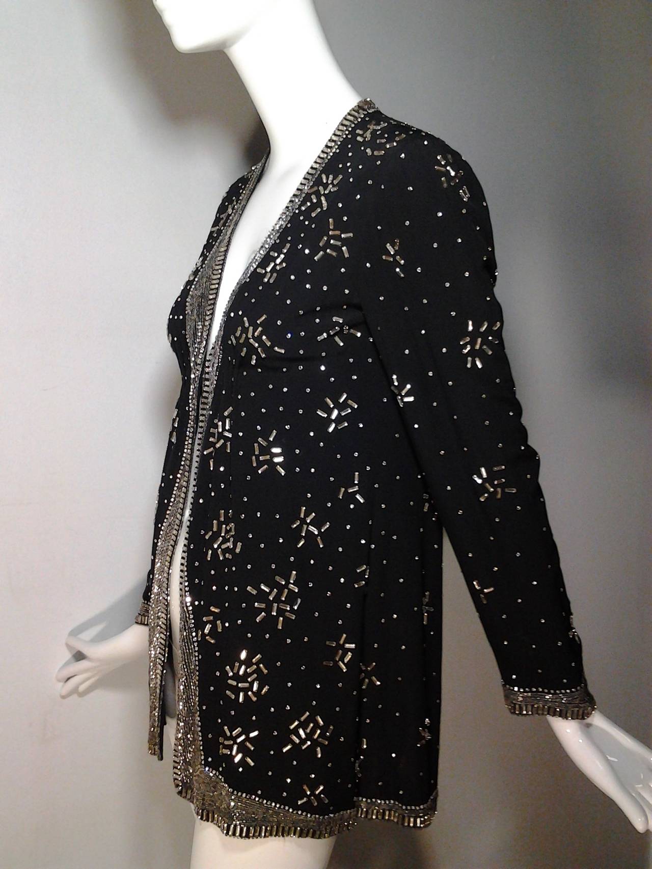 1960s Pauline Trigere gorgeous evening jacket:  Silk crepe base fabric with same lining.  Heavily embellished with baguette-shaped and small round rhinestones. 

Inner elasticized band closes jacket with hidden hook at front center, under bust,