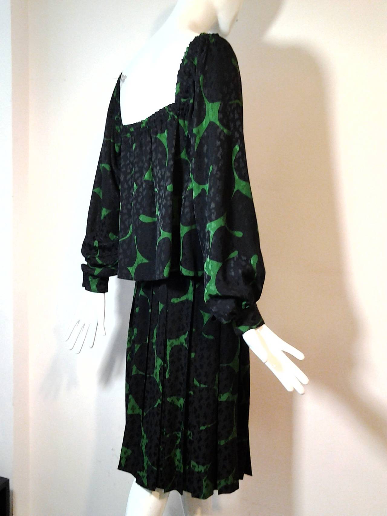 A beautiful 1980s James Galanos ensemble:  Abstract floral print over a leaf design jacquard drapes beautifully in this peasant blouse with elasticized neck and cuffs.  A pleated skirt become voluminous shorts with a stride. Elastic waist.