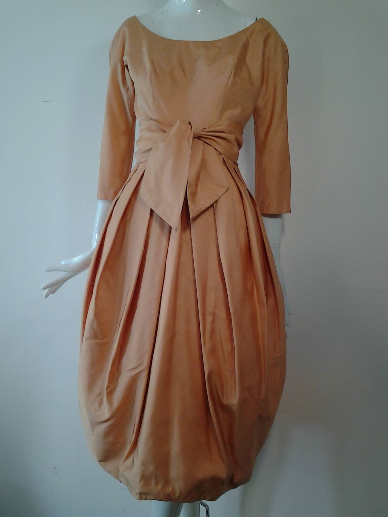 A gorgeous, stunning 1950s Suzy Perette apricot silk taffeta bubble hem cocktail dress with scoop neckline, original integral crinoline, 3/4 length sleeves.  and wide cummerbund style tie waist.