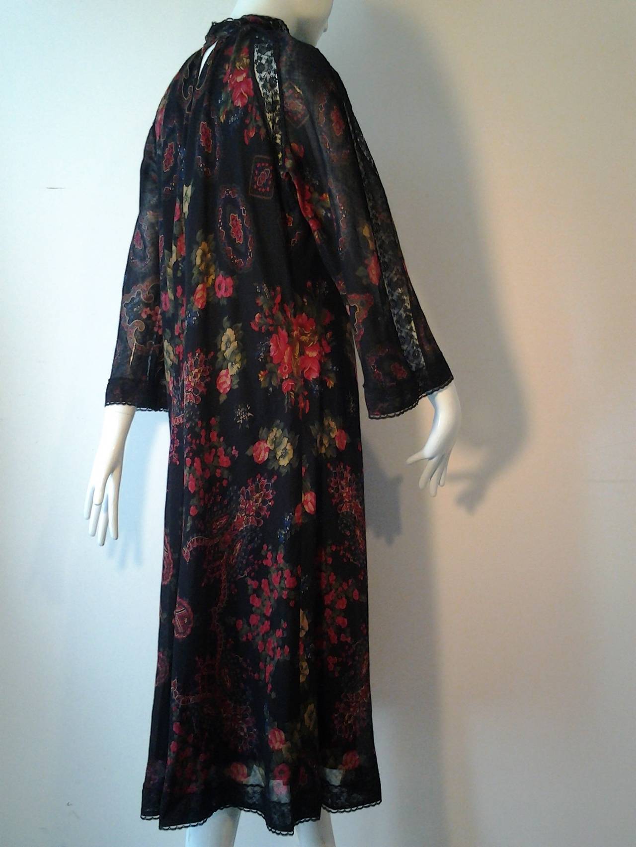 Stunning 1970s Pauline Trigere wool challis bias-cut, easy-wear floral and paisley print dress with high lace neck and sleeve insets.  Raglan style flared sleeves and silk lined. 

Back has deep keyhole closure with 2 covered buttons.