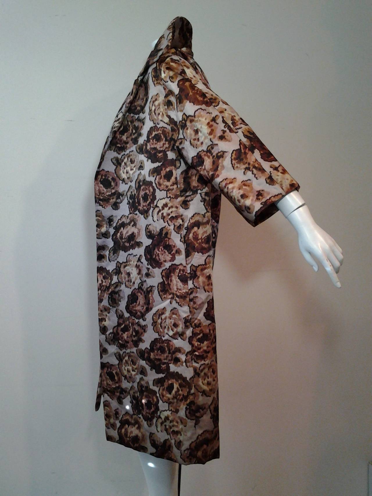 A wonderful 1950s Bonwit Teller silk floral faille evening coat.  No closures, 3/4 length sleeves, side seam pockets, notched collar.  Coat is lined with same fabric as outer fabric. 

Colors are muted gray violet background with brown and tan