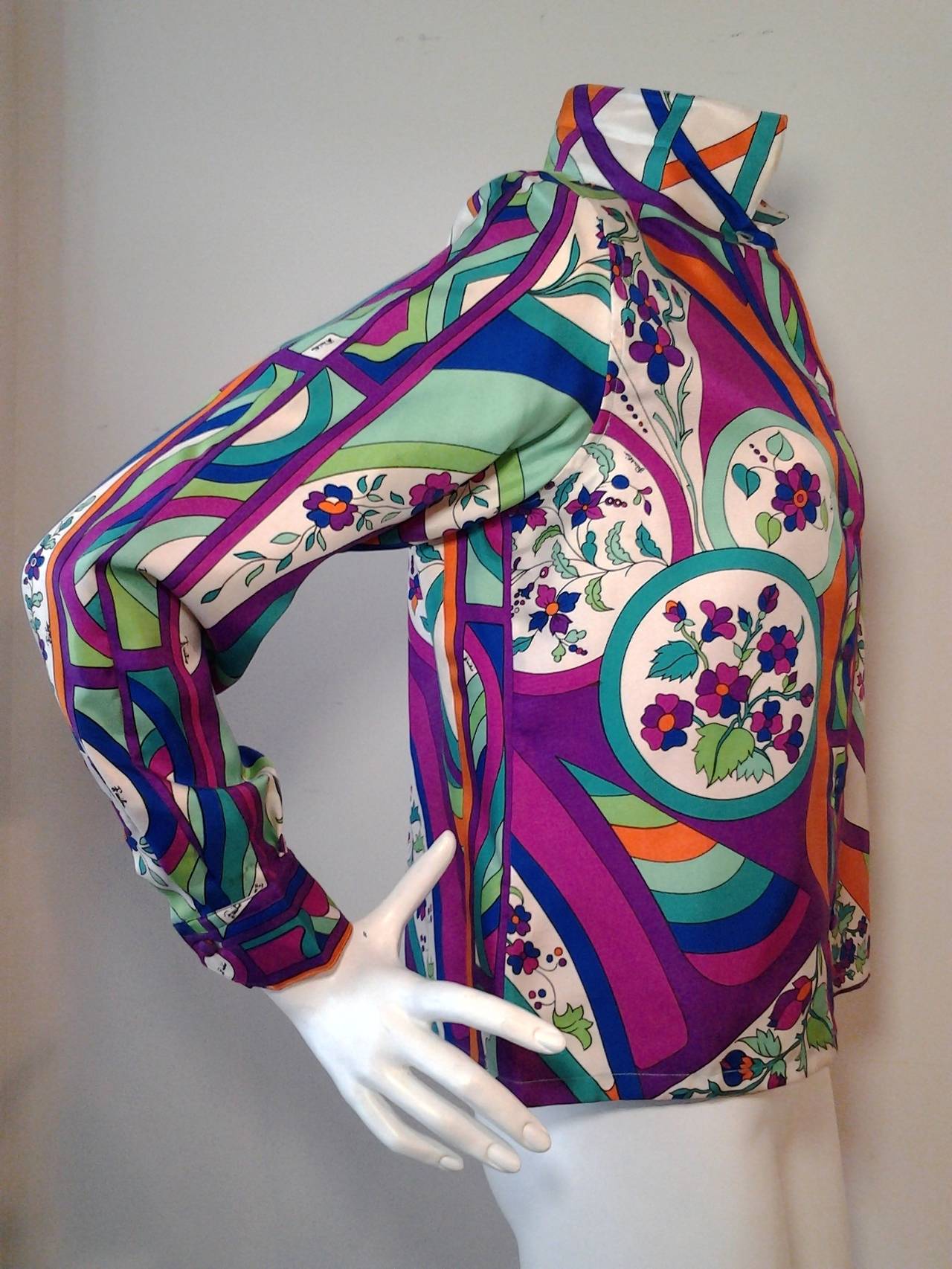 A gorgeous 1960s  Emilio Pucci silk floral and mod psychedelic print blouse with button front placket, collar and cuffs in typical Pucci fashion.  Straight hem. Originally sold at Saks Fifth Avenue.  Size marked a vintage 14.  In modern sizing it is