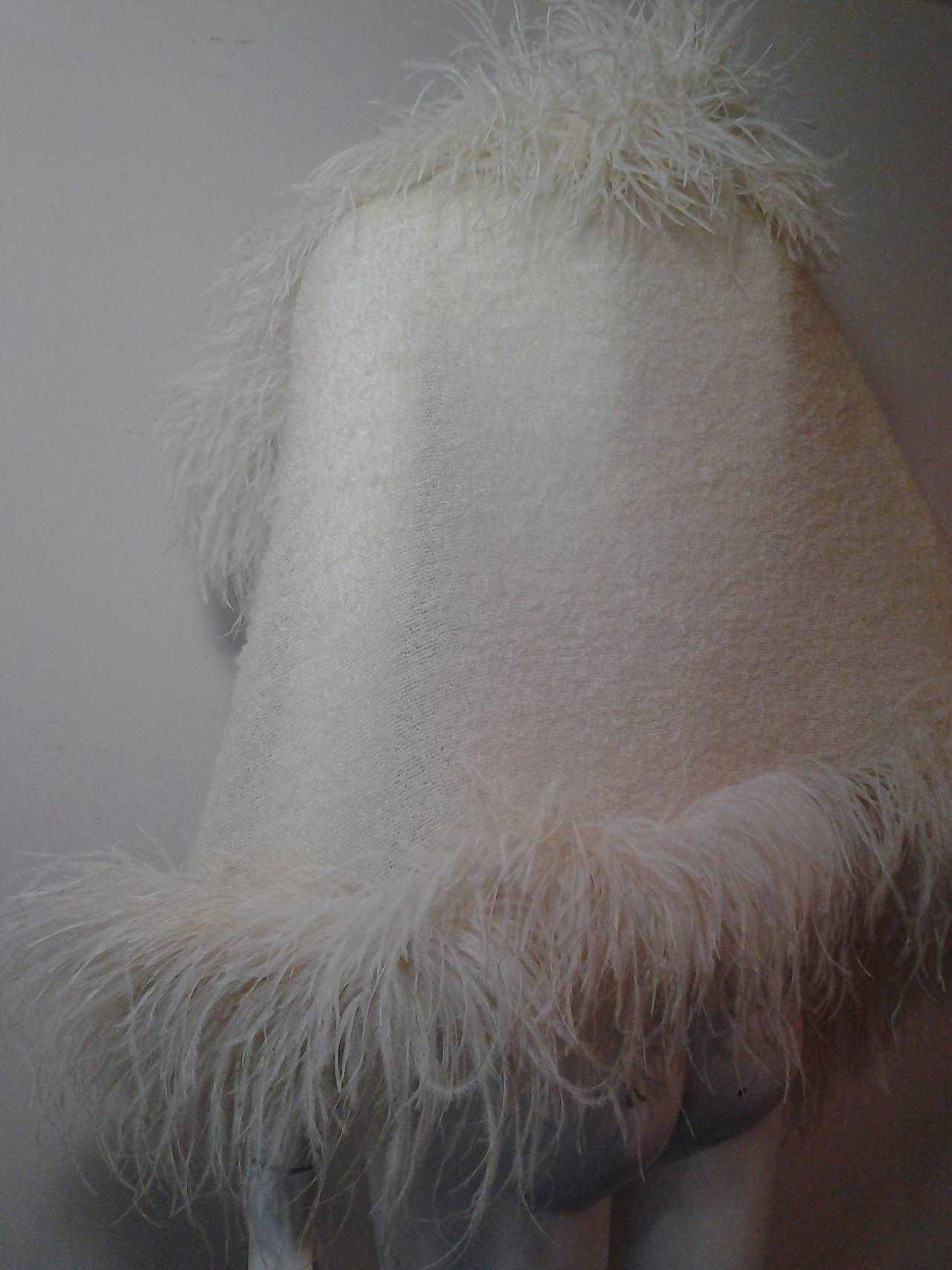 A fine mohair boucle woven wrap in a lovely cream color with ostrich feather trim on all sides.