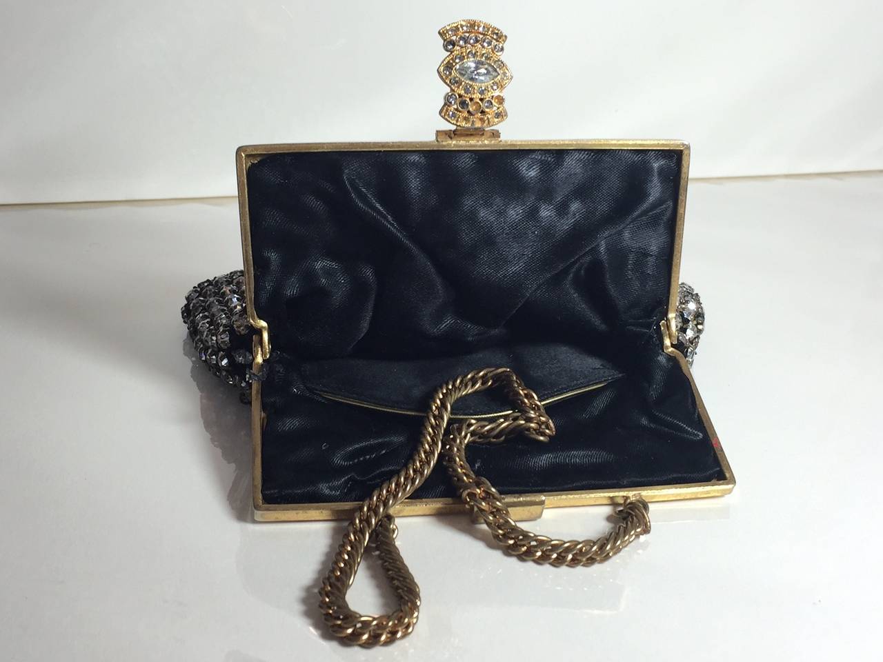 A beautiful 1930s Art Deco black mesh and rhinestone evening bag with brass frame and chain as well as a rhinestone jeweled clasp. Lined in black satin and in excellent condition. 

Frame opening measures 4
