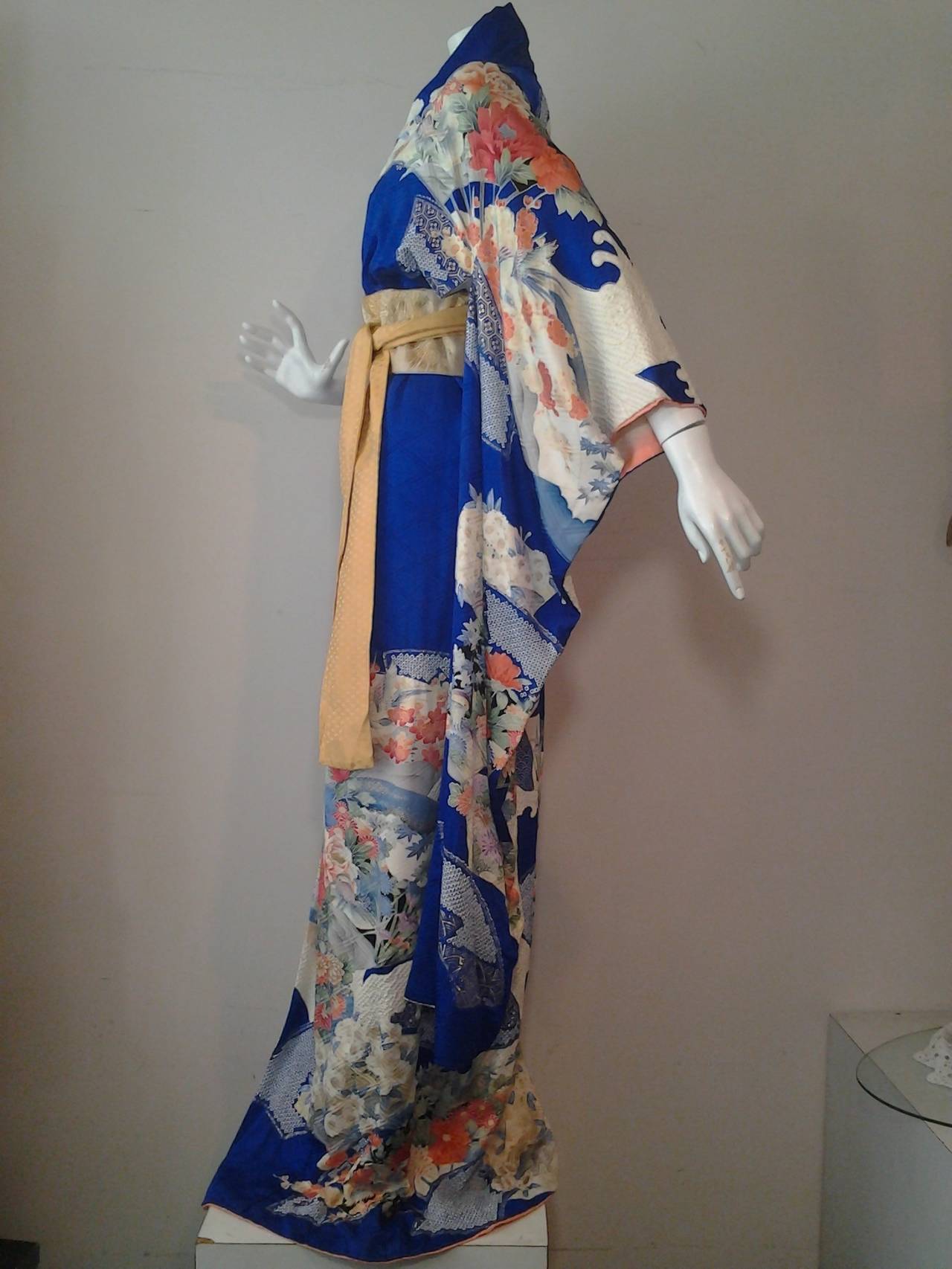 Gorgeous 1970s silk kimono in cobalt blue and florals.  Employs tie-dye techniques in some sections. Lined in cream silk . Gold silk obi included.