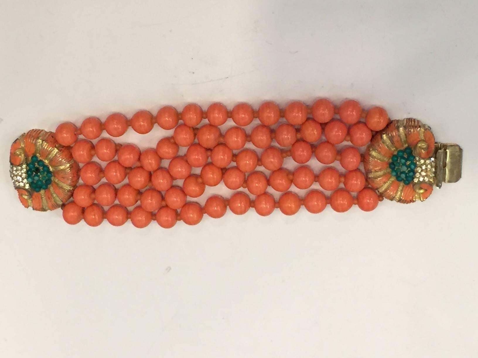 A beautiful 1960s Mimi di N coral glass multi strand bead bracelet w/ jeweled and enameled shell motif clasp.