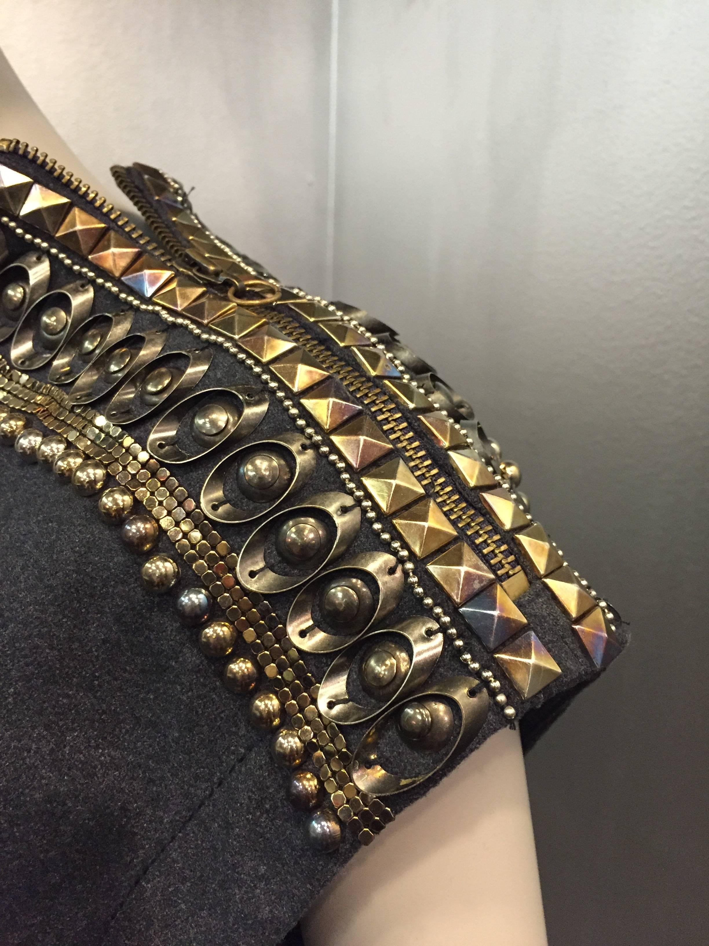 Un fabuloso vestido de cóctel de Jean Paul Gaultier:  Vestido de franela gris, de cuerpo entallado con escote de embudo, hombros abiertos con cremallera cubierta de tachuelas y metal.  Swag delantero, cremallera lateral y darting interés.  