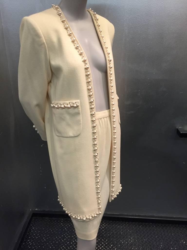 A gorgeous 1980s David Hayes cream wool straight mid-length pencil skirt and long-line faux-pearl and rhinestone trimmed, collarless jacket with patch pockets in matching trim.  