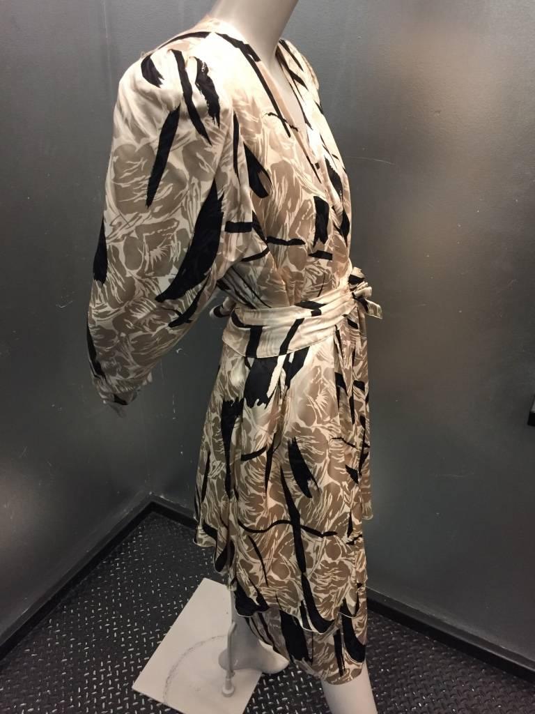 A beautiful ecru and black abstract calligraphy-inspired jacquard silk dress and jacket with original belt. Elasticized belt in dress and shoulder pads in jacket.  Cap sleeves in dress.  Jacket has button and loop closures at cuffs. Matching belt