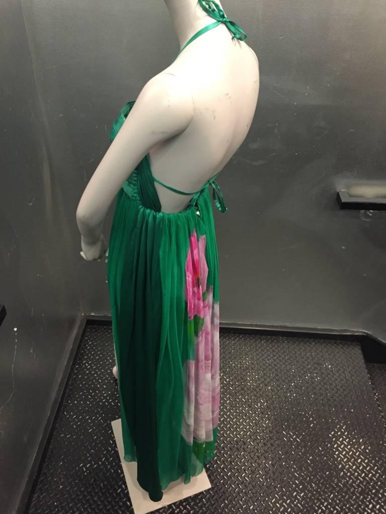 1980s James Galanos halter gown:  emerald green silk satin rouched bodice is backless with thin halter tie that can criss-cross at back. Skirt is comprised of 4 layers of gathered silk chiffon at waist, open at both sides and printed with large 