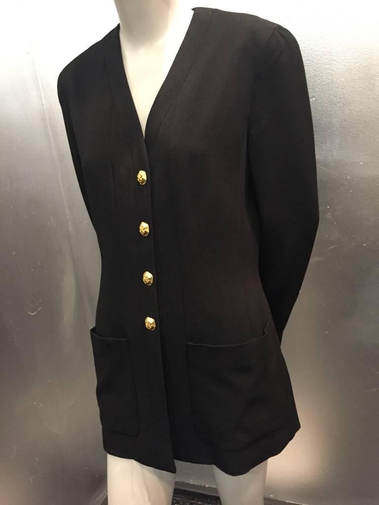 A great, classic Chanel jacket by Karl Lagerfeld.  Black rayon faille, with collarless construction front patch pockets and metal shamrock motif buttons down front and at cuffs. Fully lined. 
