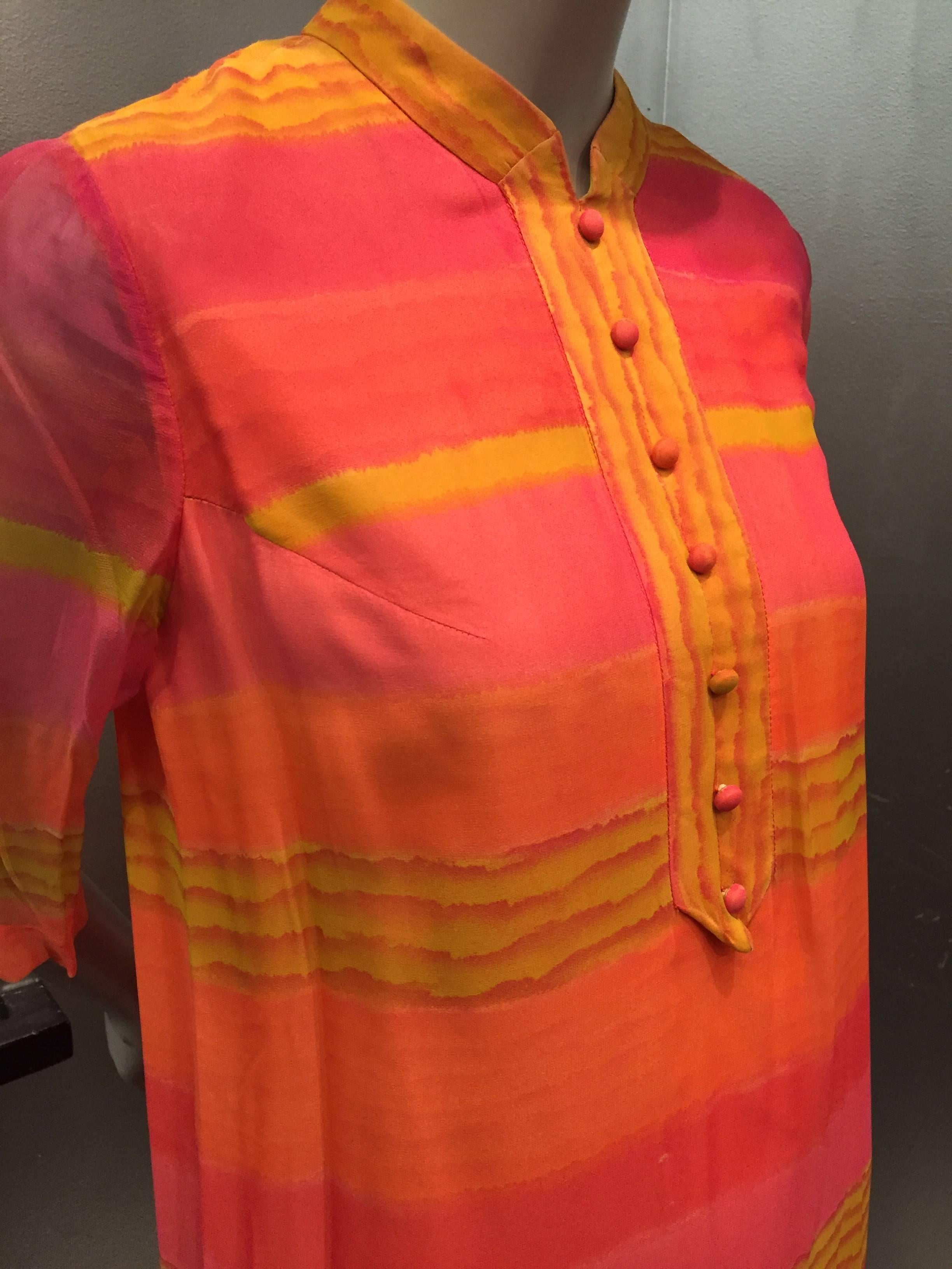 A wonderfully vibrant 1960s striped silk chiffon tunic style dress with button placket at front.  Fully lined in body, sheer in sleeves. In shades of orange, gold and fuchsia. 