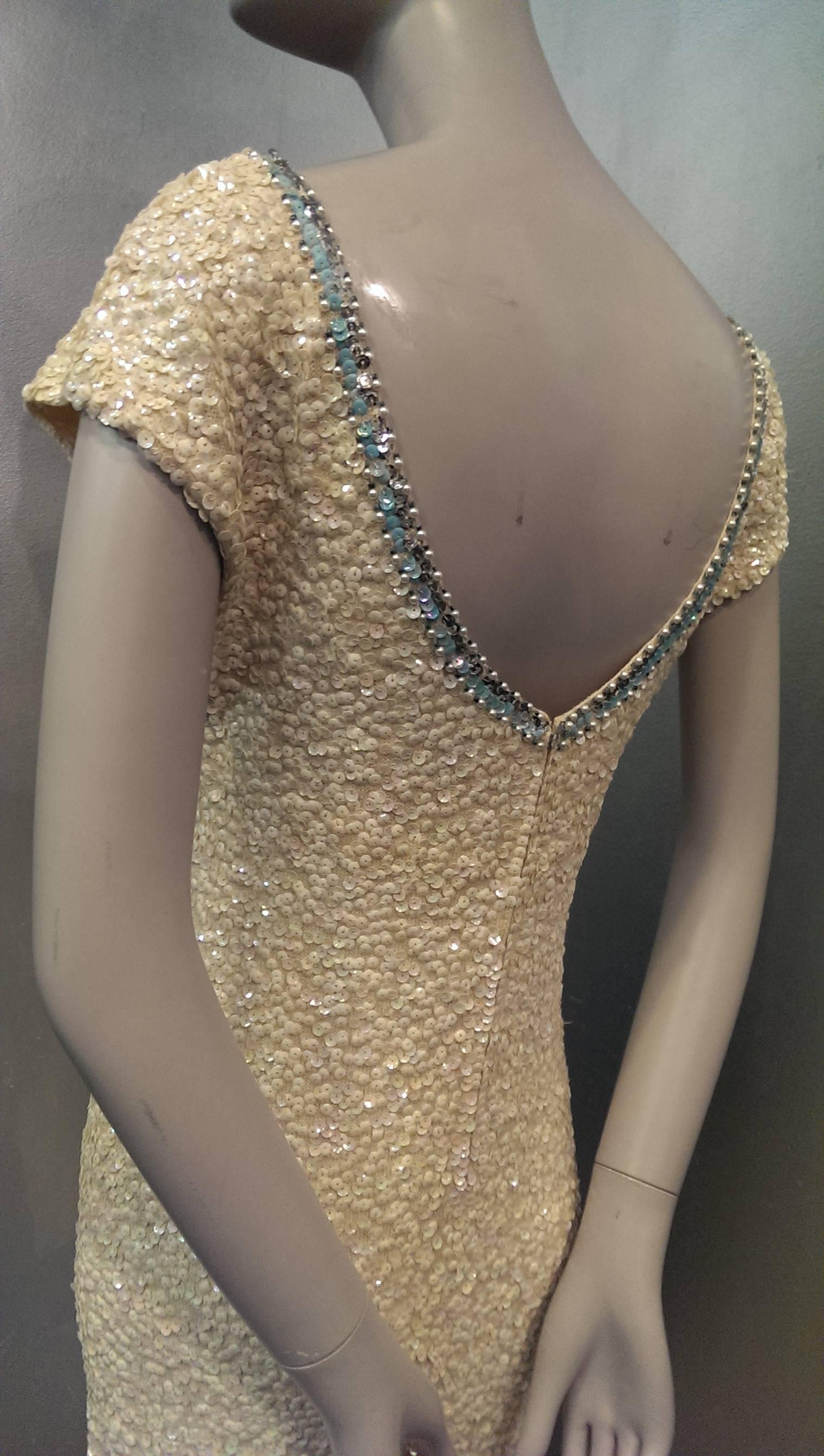 1960s Gene Shelly lightweight wool knit Empire gown with cap sleeves and low scoop neck, entirely had sequined in iridescence! Trimmed at neckline and hem with turquoise sequin and jewels. Back zipper. Elasticized Empire waist. Unlined. 