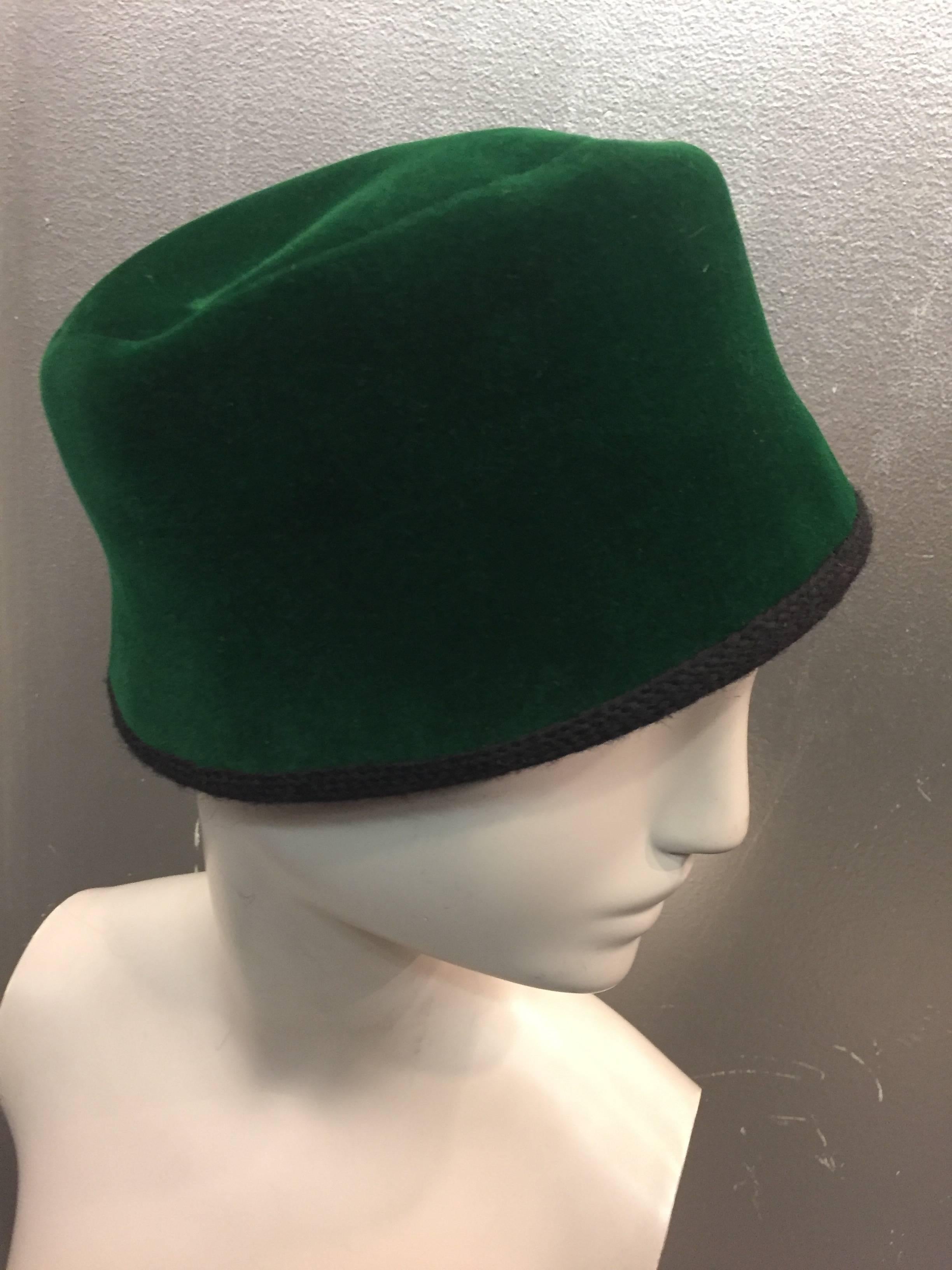 This1960s Christian Dior Evergreen Velvet Felt Fez has a chic black knit back bow.  The inside circumference measures 22 inches and is trimmed in black wool knit.  The crown measures 4 inches tall.  Made in France.