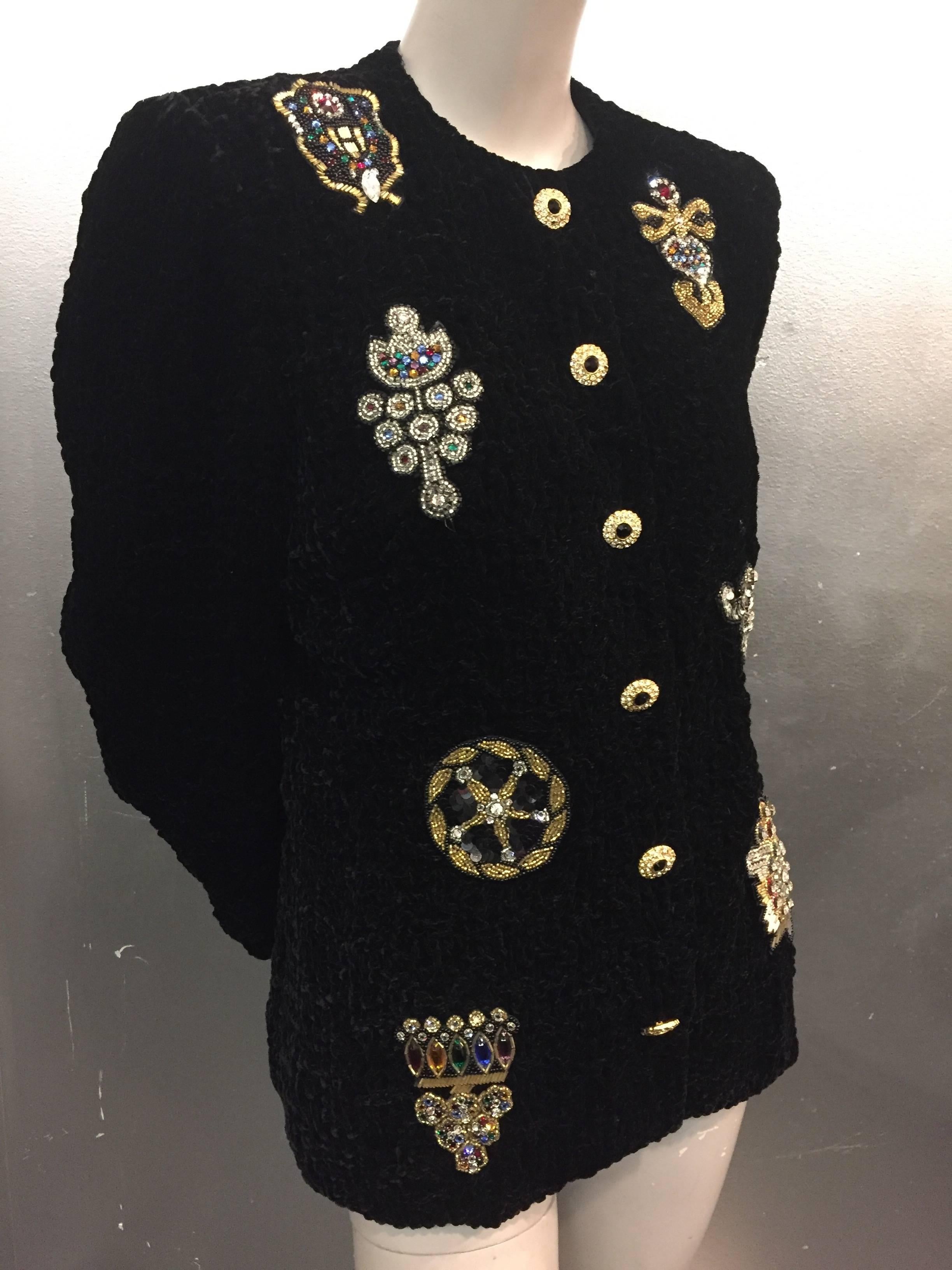 A fabulous 1980s black ruched velvet evening jacket with front snap closures and rhinestone buttons on top.  8 large beaded and sequined medallion appliqués embellish the front. 