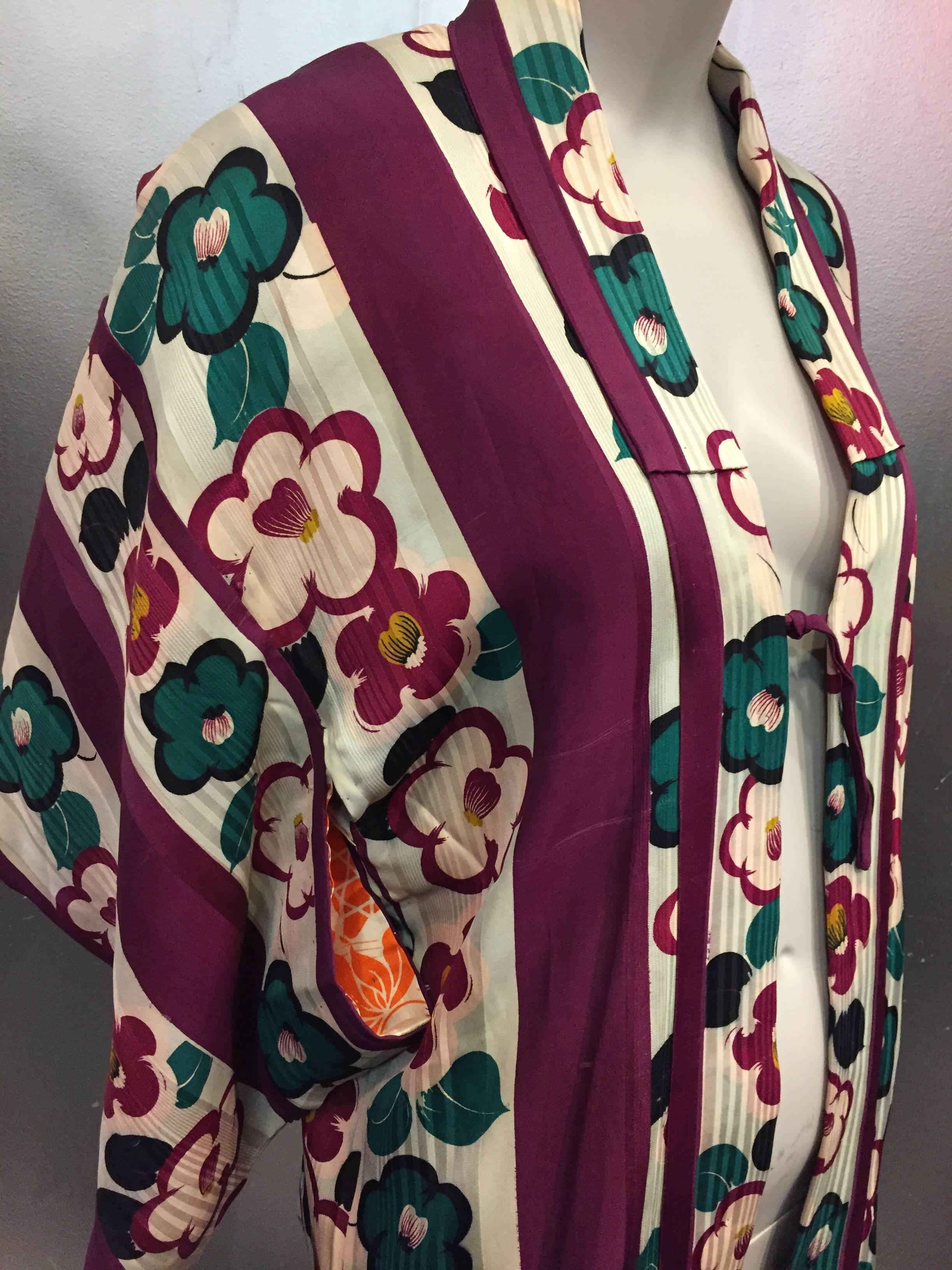 A gorgeous and fresh 1940s burgundy, teal and ivory print and awning stripe short kimono jacket.  Orange and Cream patterned shoulder lining.  Front center tie.