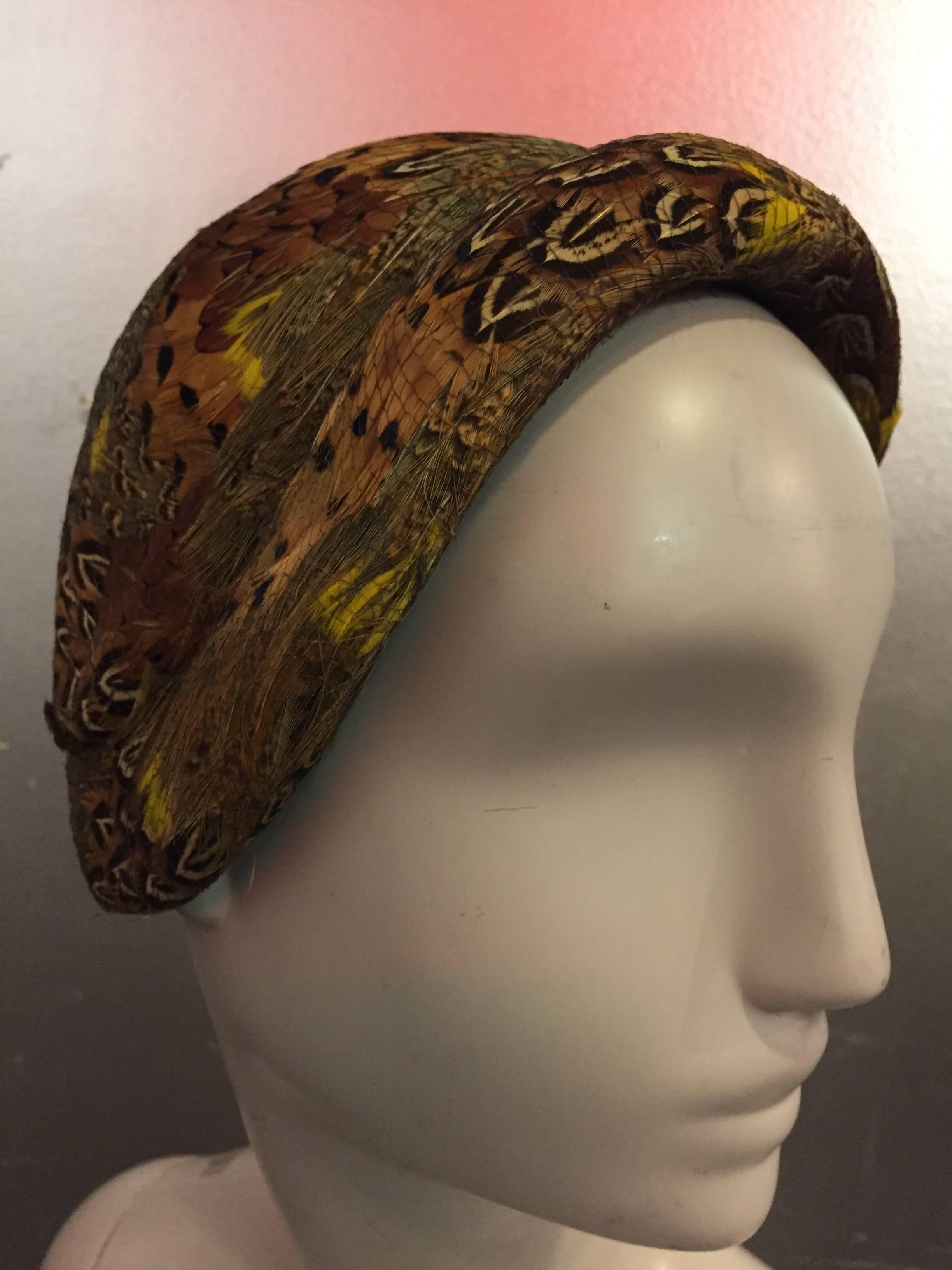 1950s Joseph Magnin gorgeous pheasant feather and brown felt capulet with sculpted brim and net overlay. In a brilliant color palette with vivid pops of yellows.  