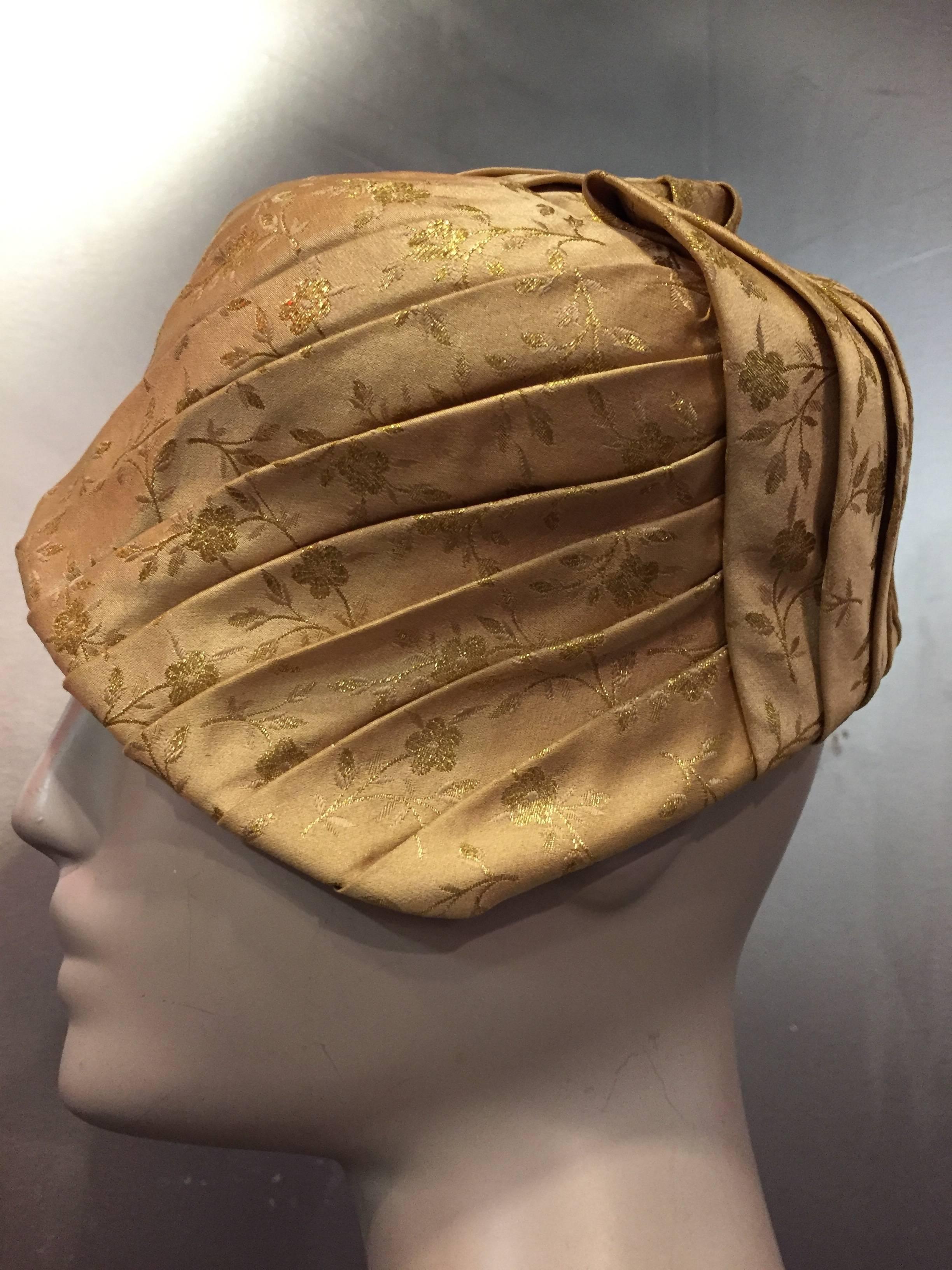 1950s Tatiana gold silk lamé brocade pleated asymmetrical cocktail hat with wired brim and grosgrain band.  Size medium. 