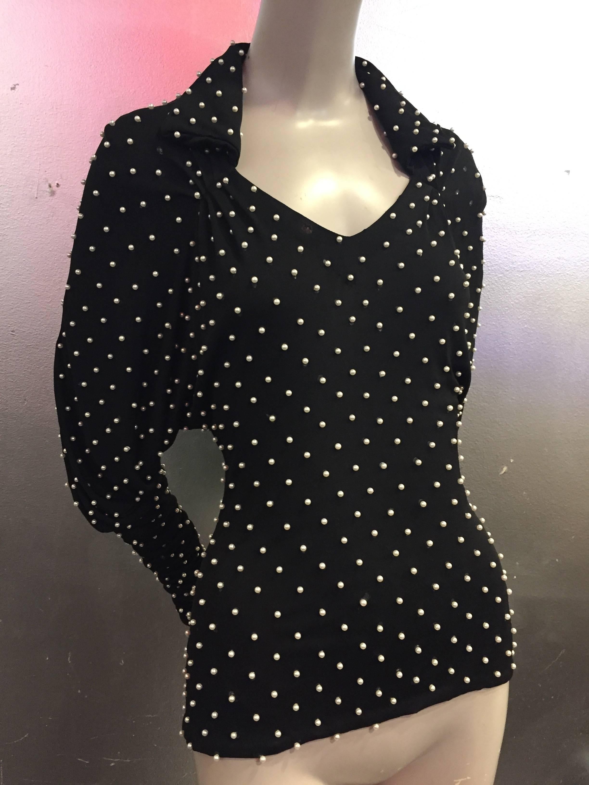 A fabulous 1980s Norma Kamali black matte rayon jersey blouse with collar, v-neck and Dolman push-up sleeves entirely studded with white pearls.  Sleeves are 43