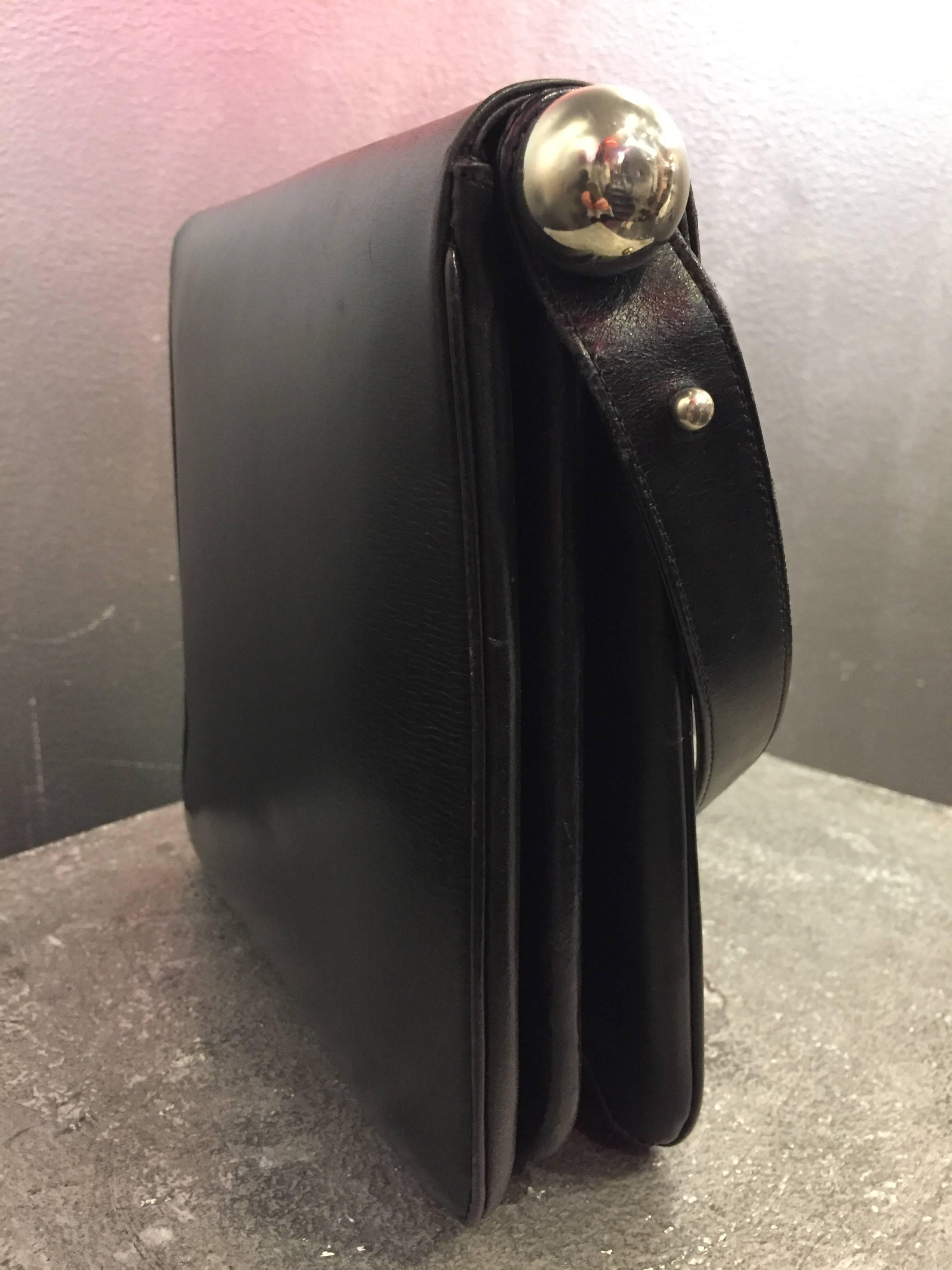 A pristine 1960s high-quality mod Saks Fifth Avenue black calf skin shoulder bag with adjustable--to double length--strap.  Large rectangular pull tab closure.  Chrome ball detail and two accordion-style expandable compartments.