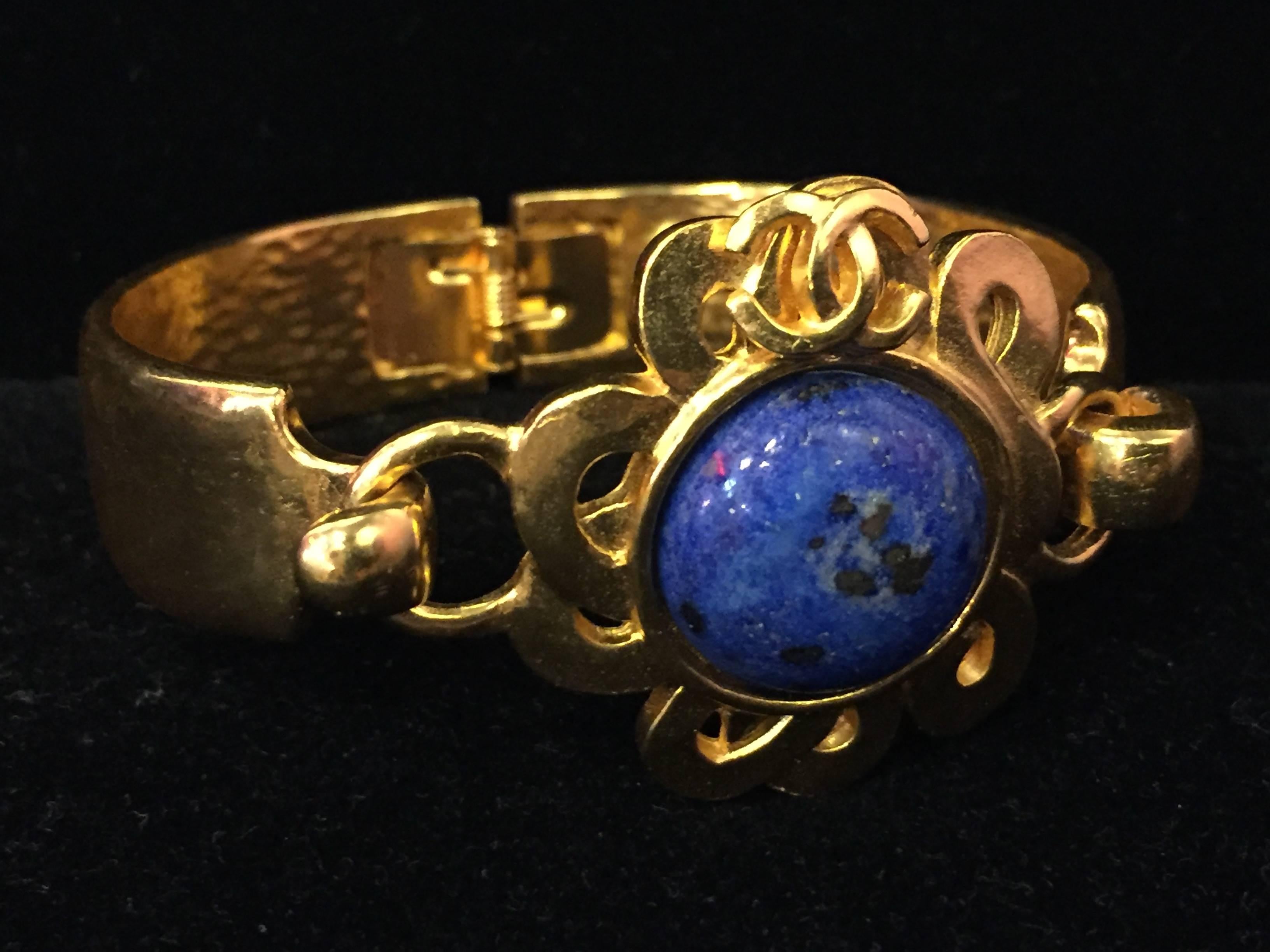 A fabulous 1997 gold-tone hinged bracelet with front medallion with hook closure.  Sun motif with a lapis lazuli center stone. 