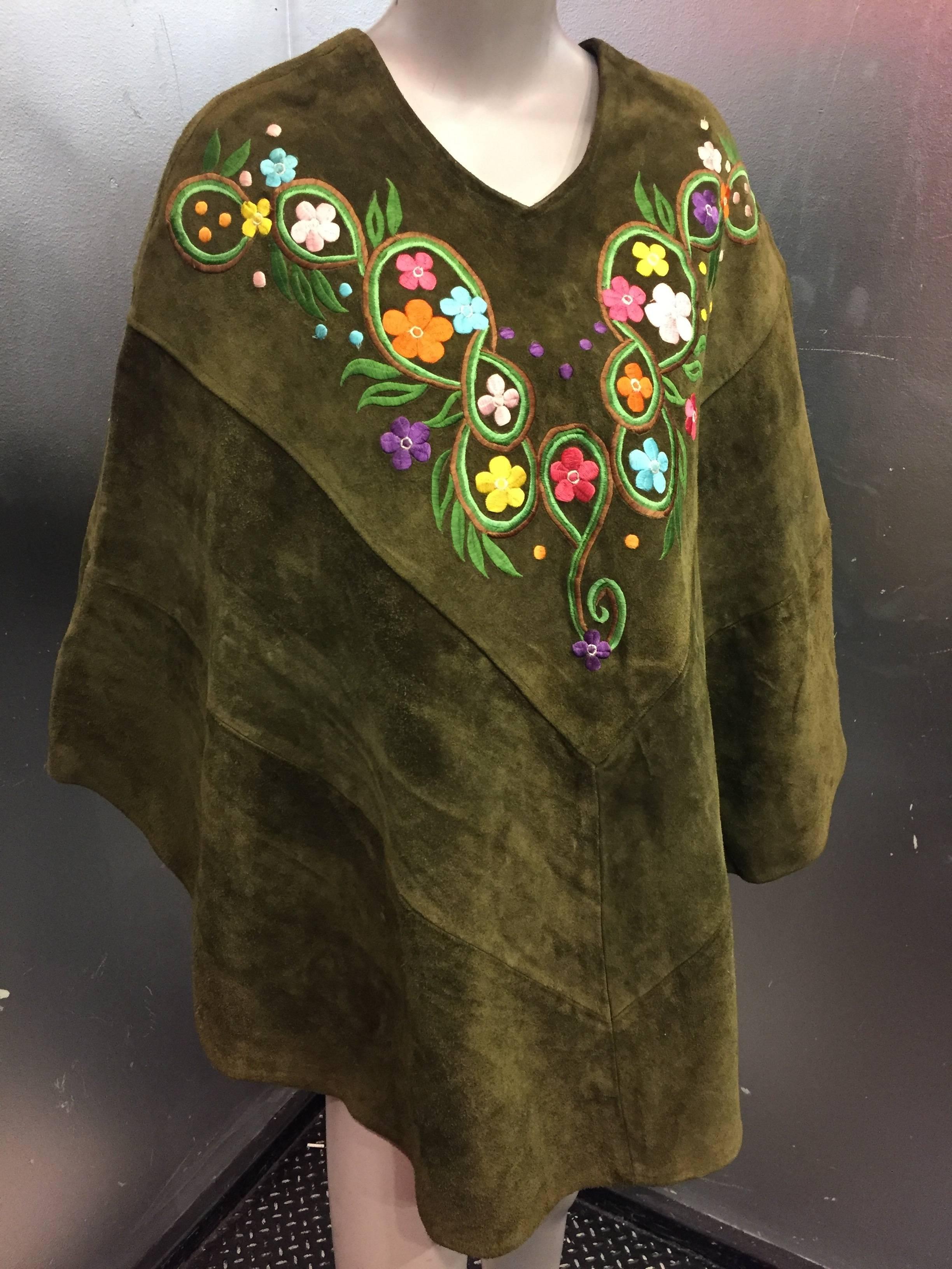 This groovy Mexican poncho with embroidered flowers has a true 60's Hippie flower power feel. Made of a substantial suede and adorned with multi-color flowers. This poncho is perfect for festivals or concerts, and is a great compliment to any true