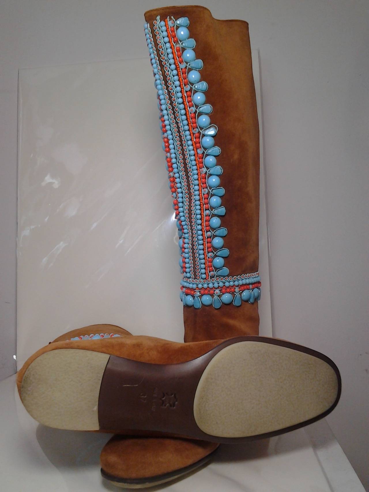 A gorgeous pair of pristine Miss Trish of St. Moritz tobacco brown suede boots:  Never worn. No heel, moccasin style zips up back. Beautiful faux turquoise and coral beading.  Size 37.