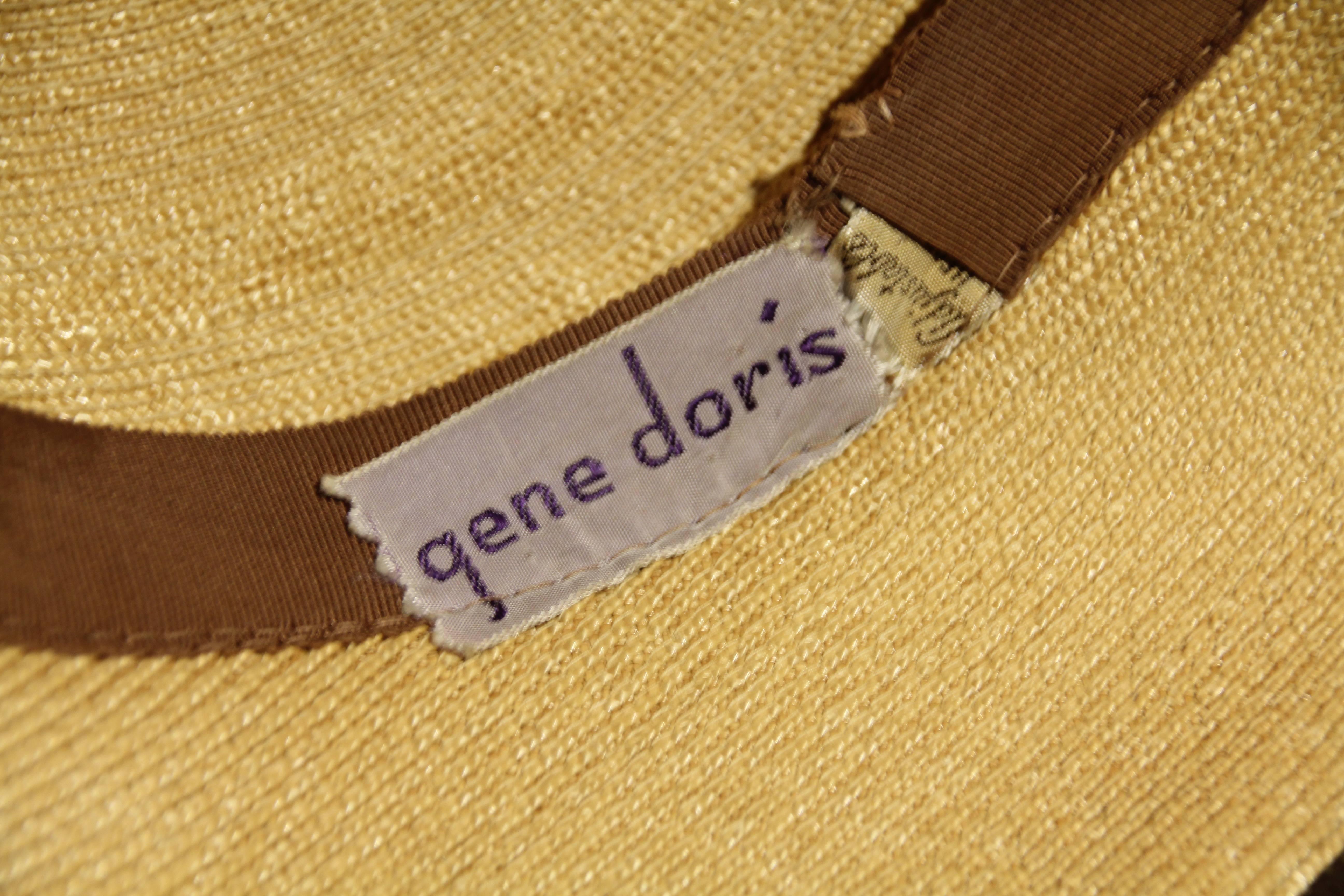 A charming 1940s Gene Doris sculpted brim natural straw hat with a narrow brown ribbon hat band and inner grosgrain band. 