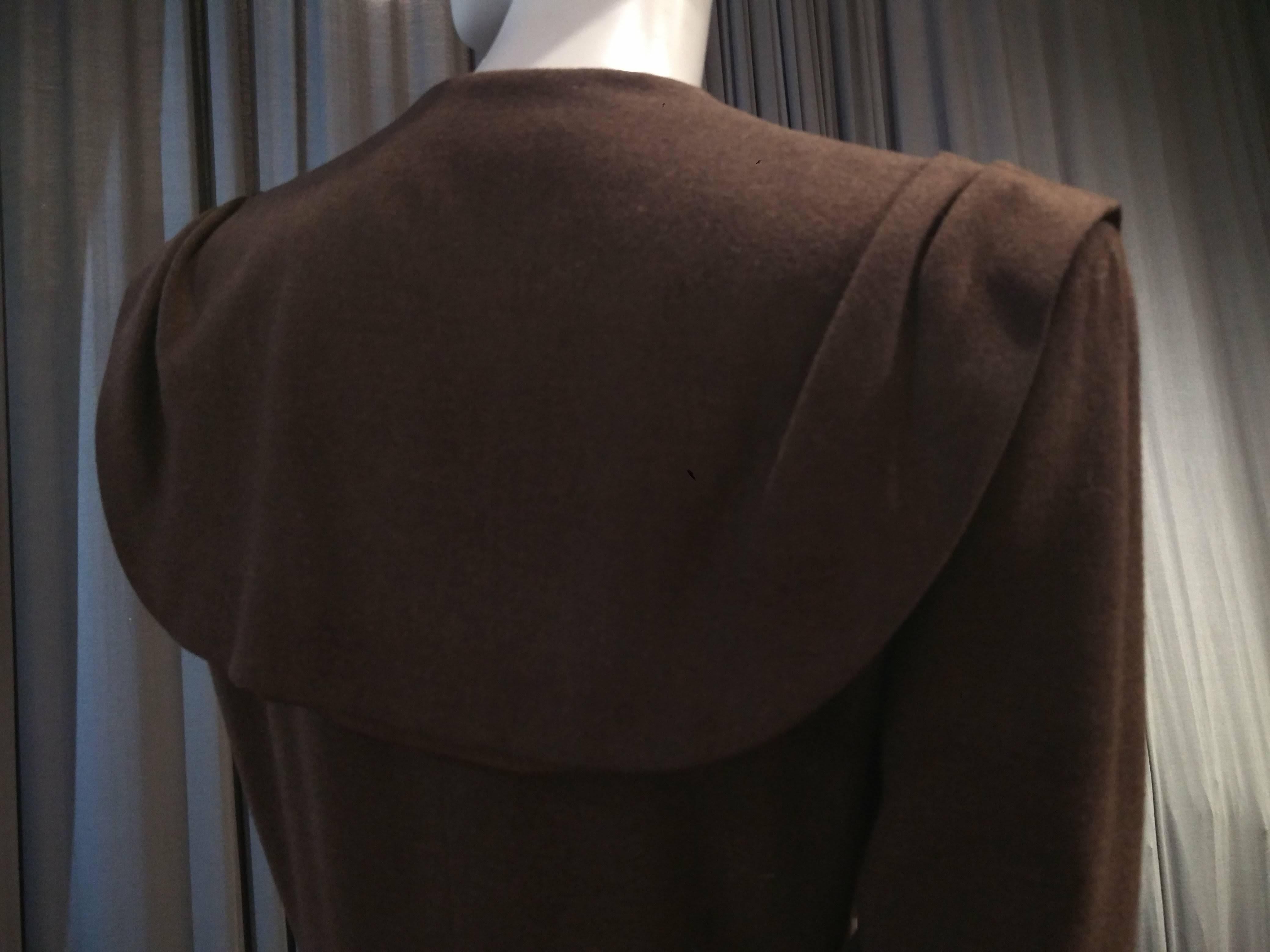 A fabulous 1940s Adrian Original skirt suit in chocolate brown, slightly heathered wool: Substantial signature Adrian shoulder pads, large rounded collar / caplet extending out to shoulder's edge and draping in the back. Original brass buttons at