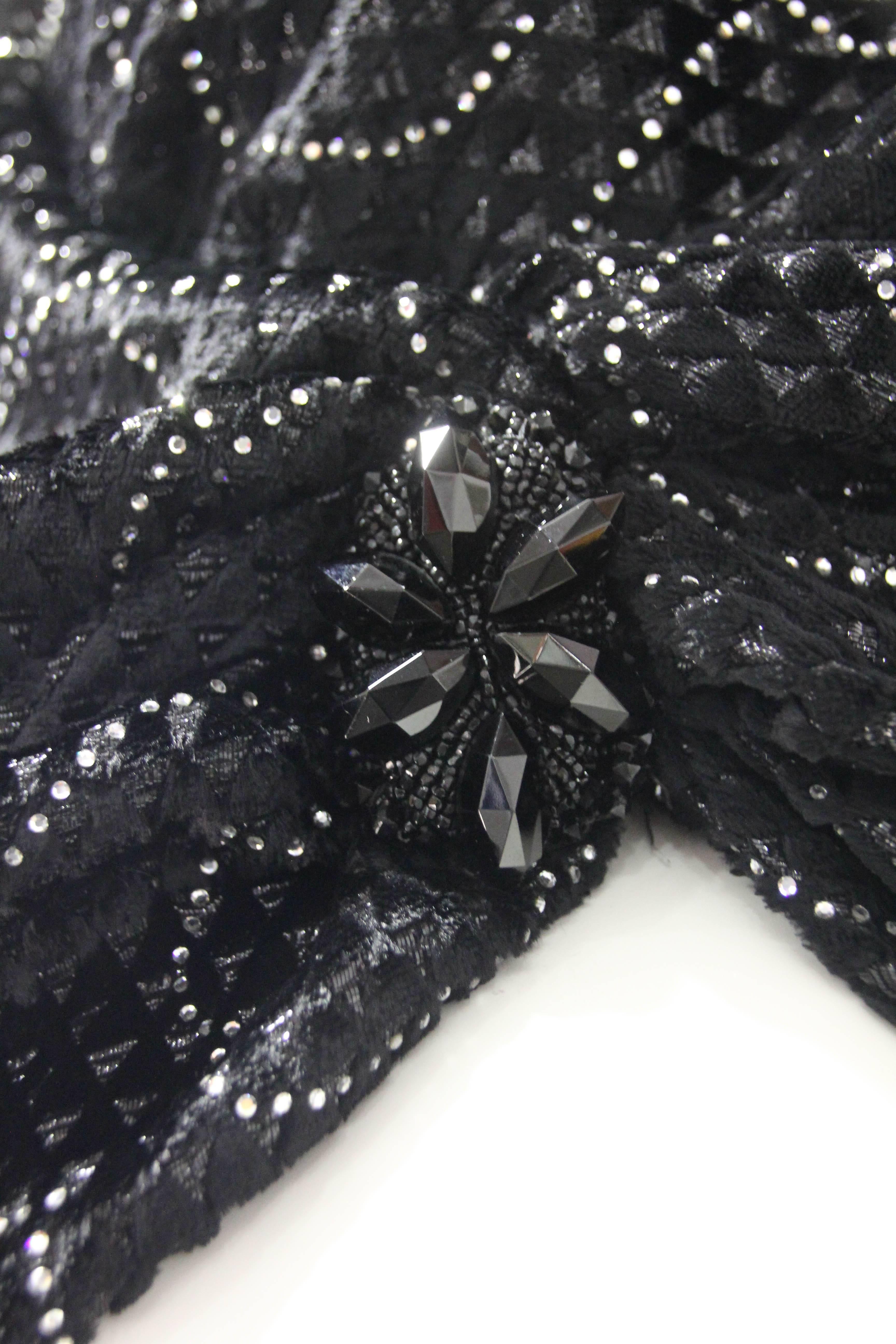 1980s Emanuel Ungaro Couture wrap top in black embossed velvet with tiny rhinestones set in a tracery pattern throughout. Blouse has a blouson drape style with a fitted waistband underpinning it for security and to keep it properly in place.  Side