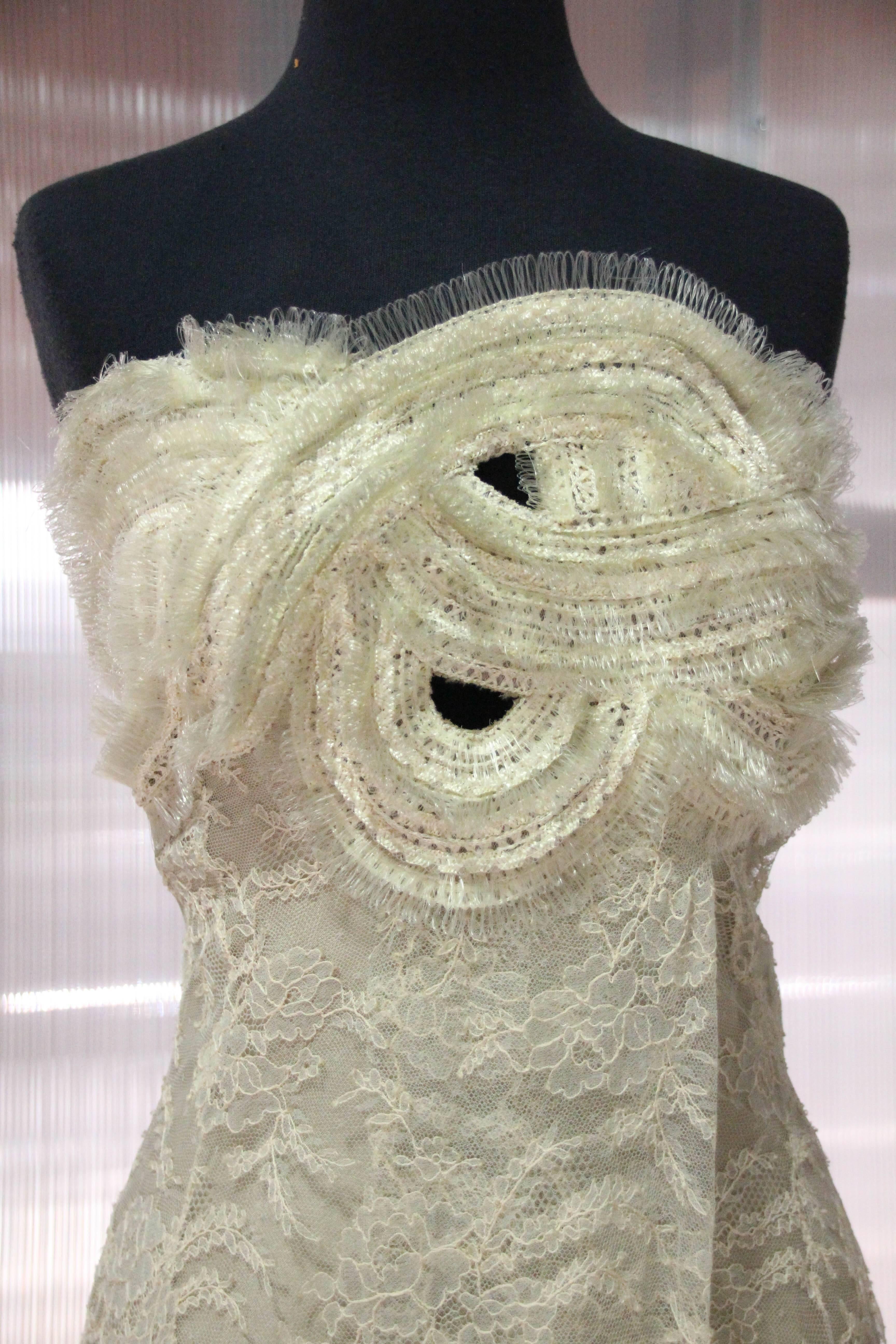 1990s Gianfranco Ferre ecru French lace and horsehair braid structured strapless gown with bodice peek-a-boo sections formed by serpentine braid work.  Overlay lace wrap front with high slit. Fully lined in silk charmeuse. Side zipper and hook and