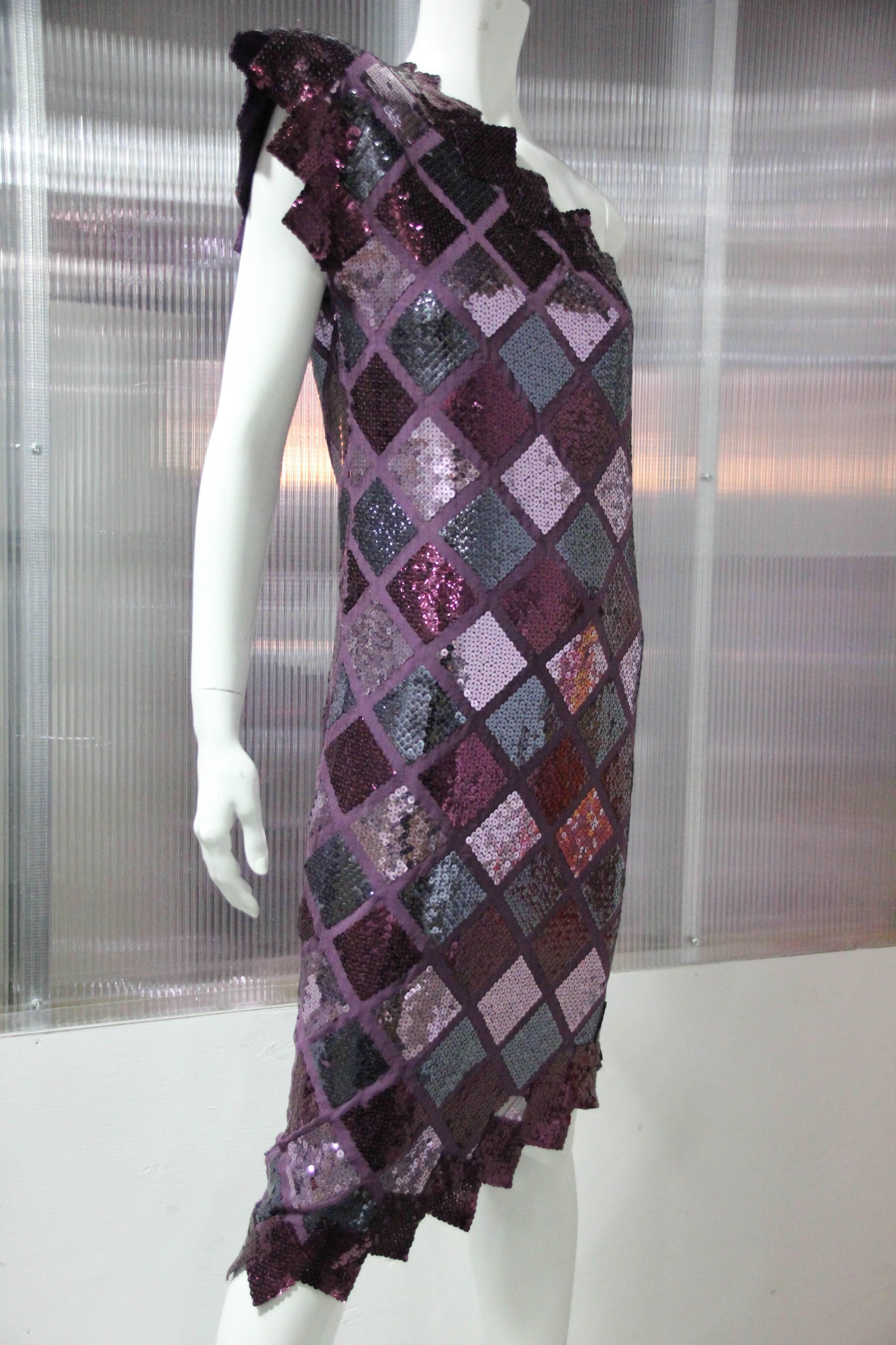 1980s custom-made, one-shoulder, sequin and satin dress, in burgundy and gunmetal harlequin pattern.  Saw tooth hem and decolletage with a structured stand-up padded shoulder and silk lining.
Striking !
