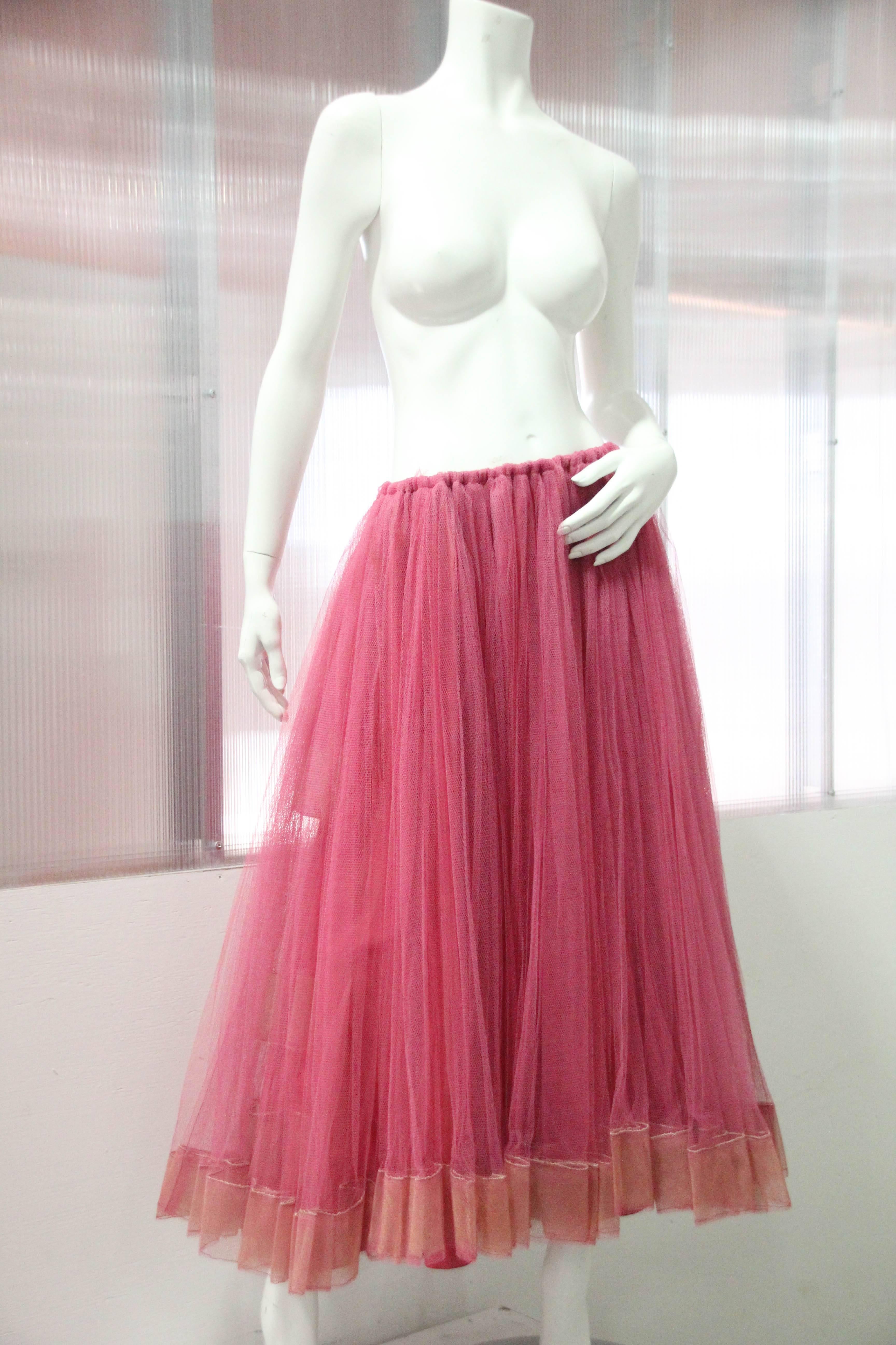 1950s Melon-color tulle crinoline with many layers of tulle and horsehair trim, silk lined and elastic waist. This underskirt was salvaged from an incredible demi couture gown and was created to be worn under or without an evening gown.
Color varies