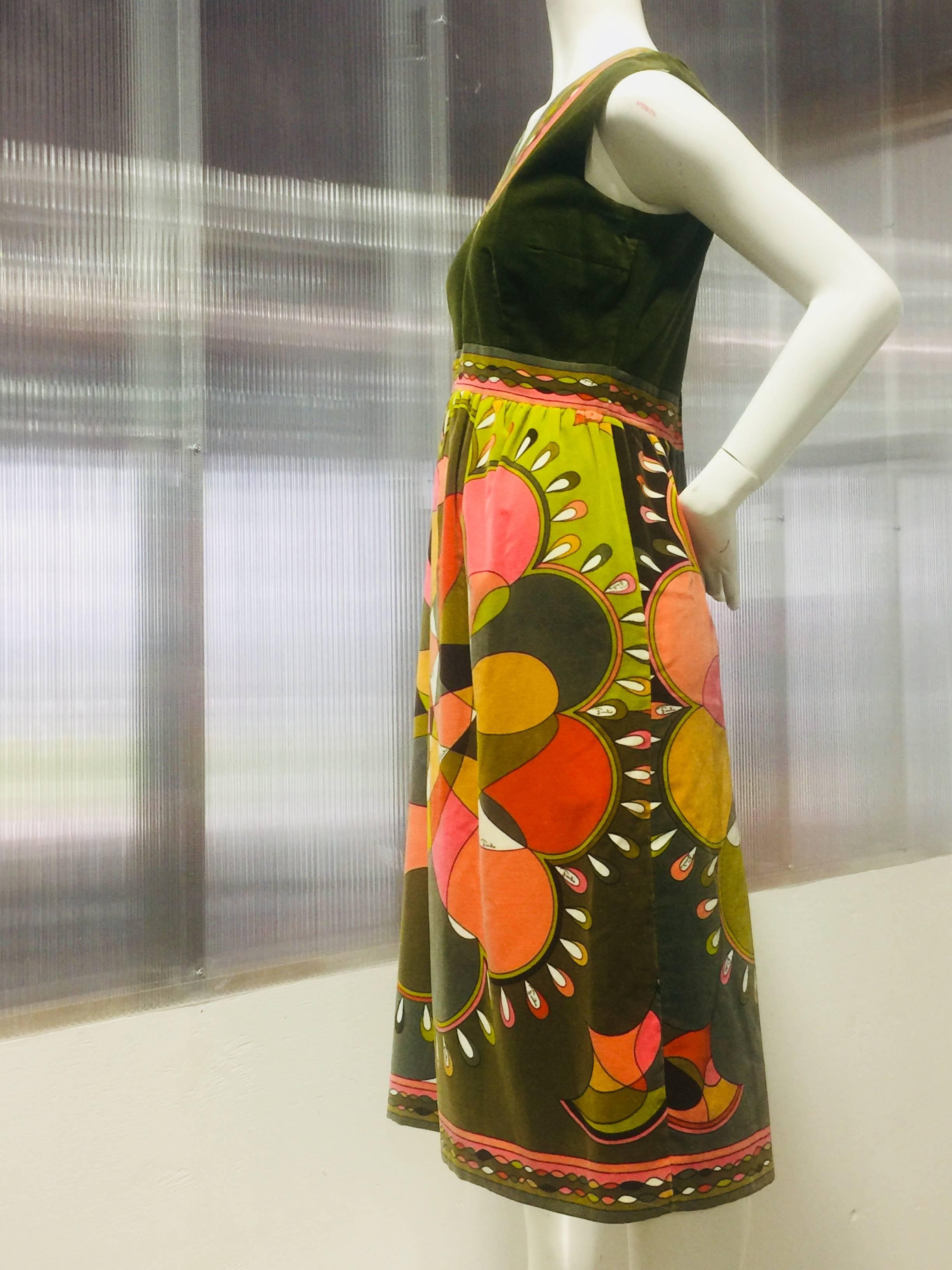 This iconic 1960's velvet Pucci print dress in deep olive green ,orange ,yellow and pink exude energy with the fusion of color that he mastered in this modern day design. The sophisticated couture quality baby doll style cut dress is framed with a