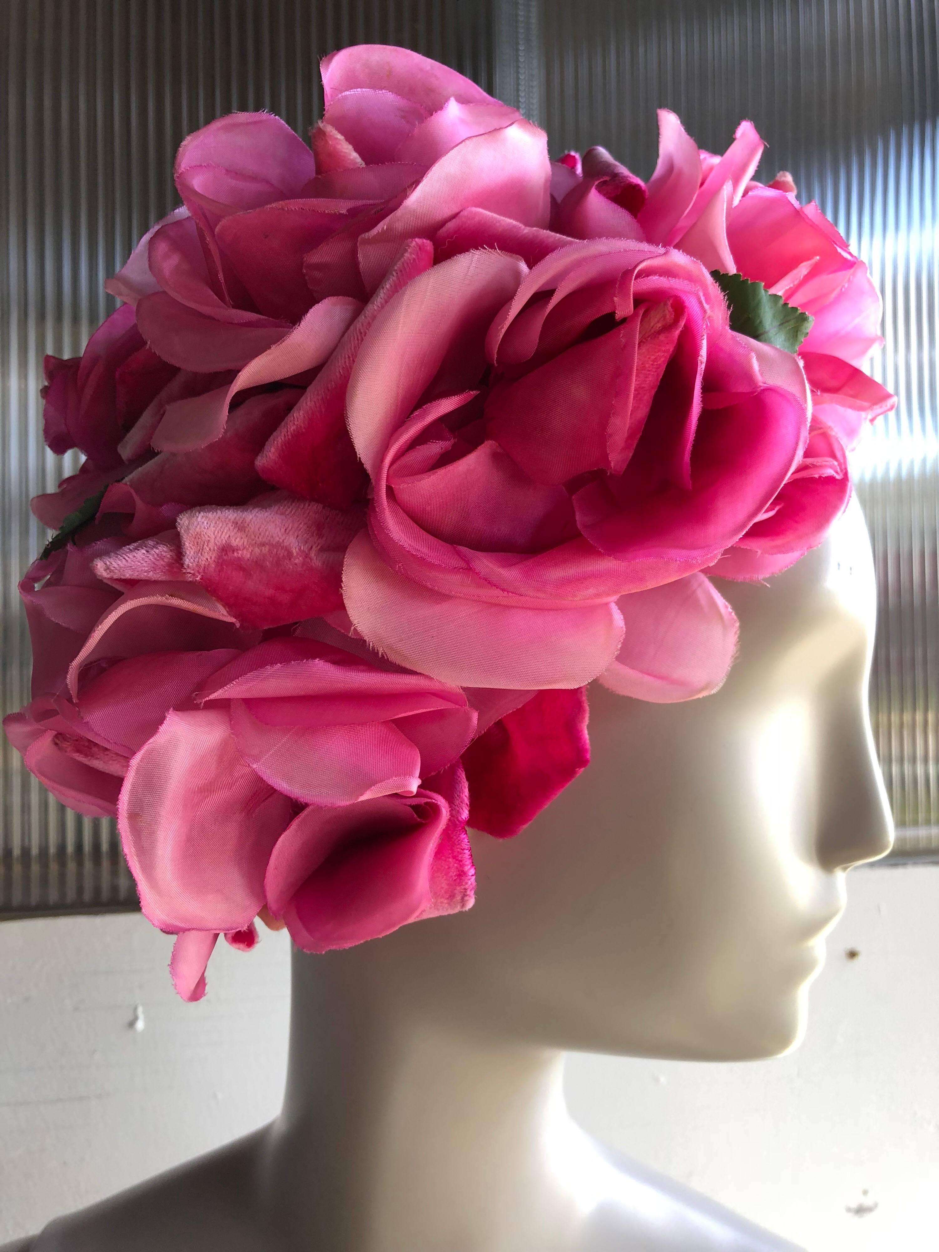 A gorgeous 1960s Saks Fifth Avenue floral hat of vibrant pink silk roses on a stiff net base. Large size lush flowers cover the entire hat.  Medium size. 
