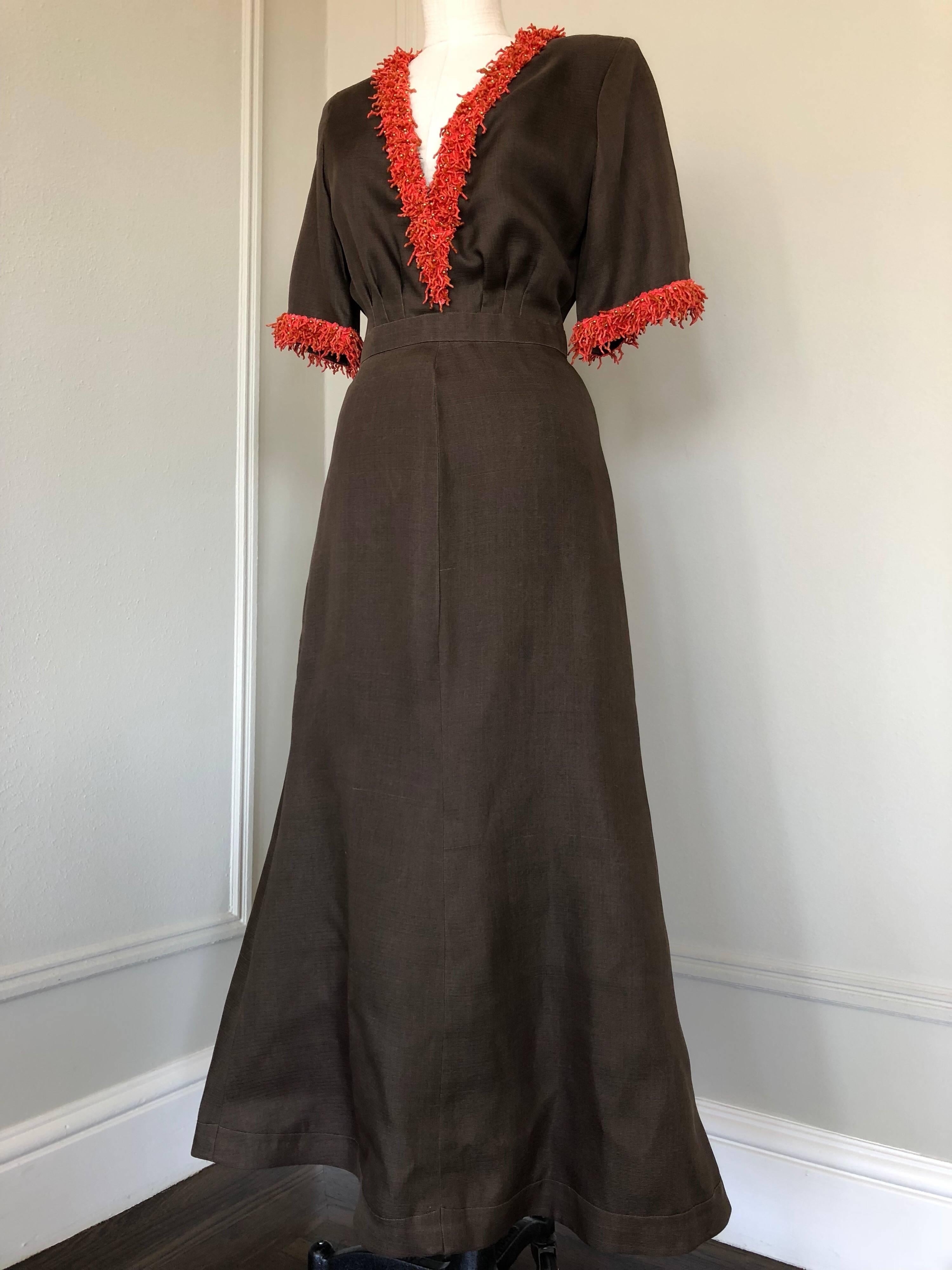 A very elegant Nina Ricci Couture Summer gown in rich chocolate silk Gazar fabric is smartly tailored to enhance the shape of this crisp design. The design features elbow length sleeves a fitted banded waist and a slightly flared hemline. The deep V