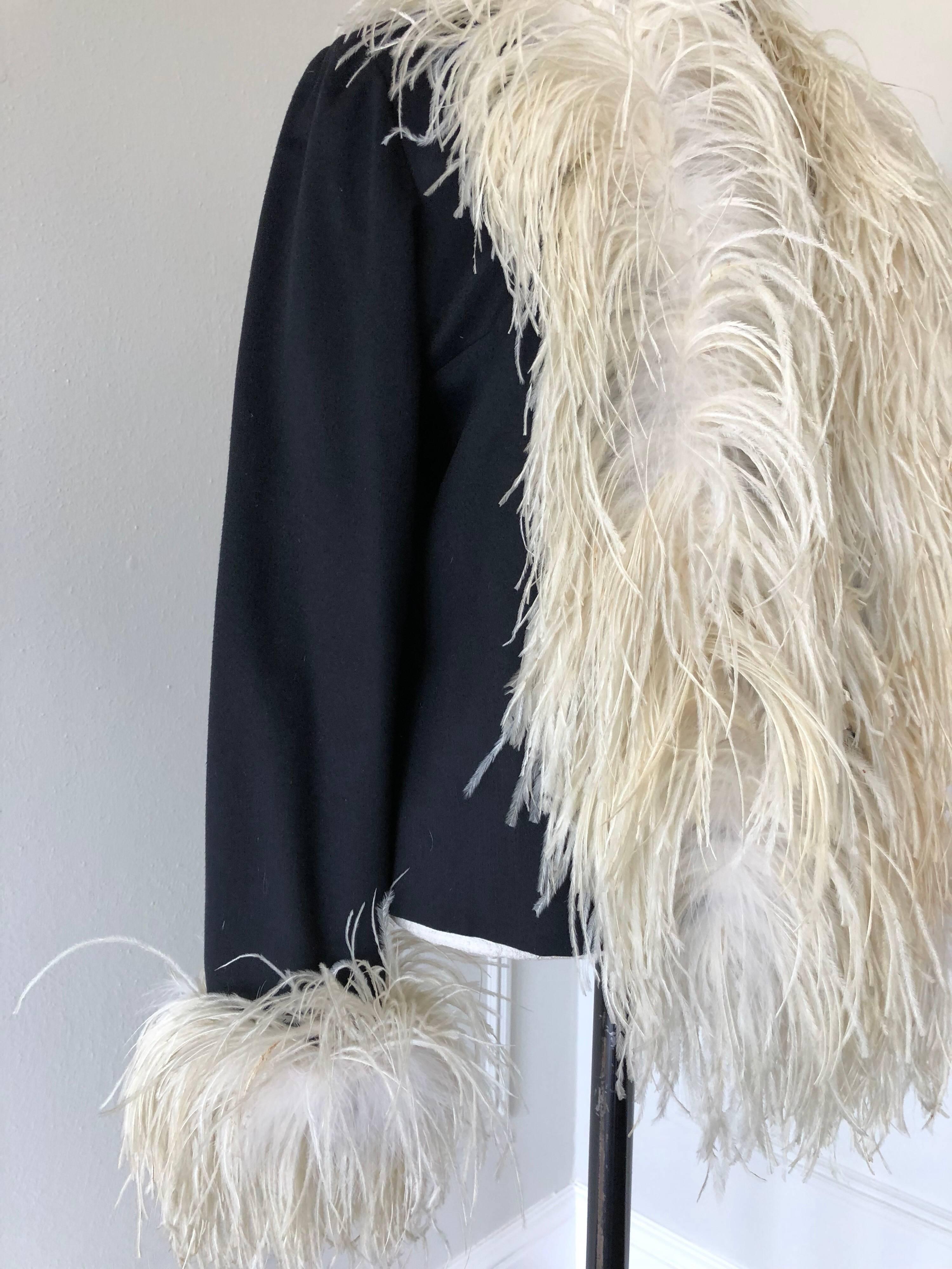 A fabulous 1960s black wool and cashmere felted jacket in a boxy cut, lined with extravagant amounts of cream color ostrich feathers trimming front neckline to hem and cuffs!  