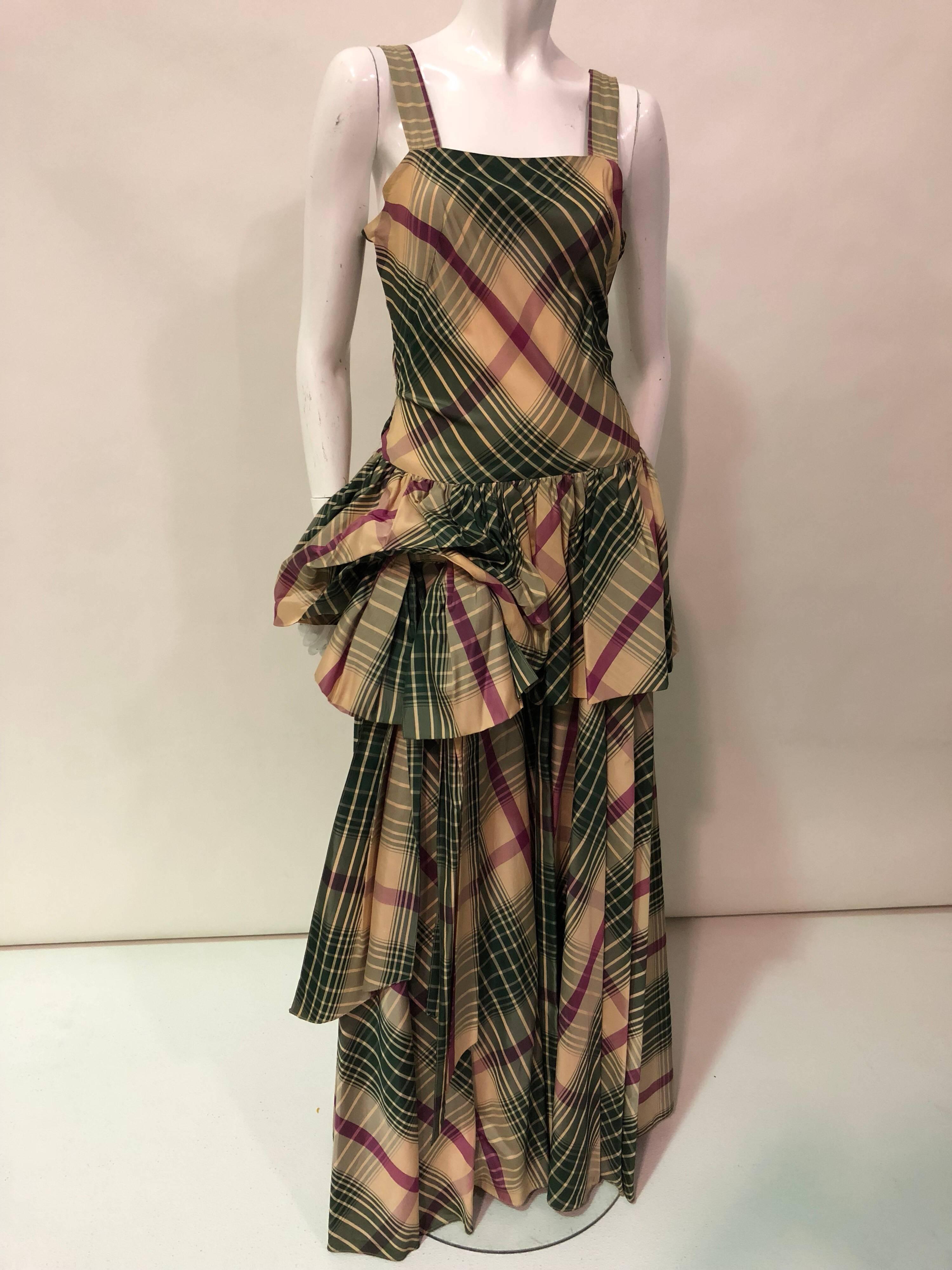 A stunning 1940s Jourdelle of Hollywood Originals plaid taffeta bustle-back gown! In shades of forest green, plum and tan, this gown is cut on the bias at front side of bodice for contour fitting.  Skirt is voluminous with a fantastic full peplum