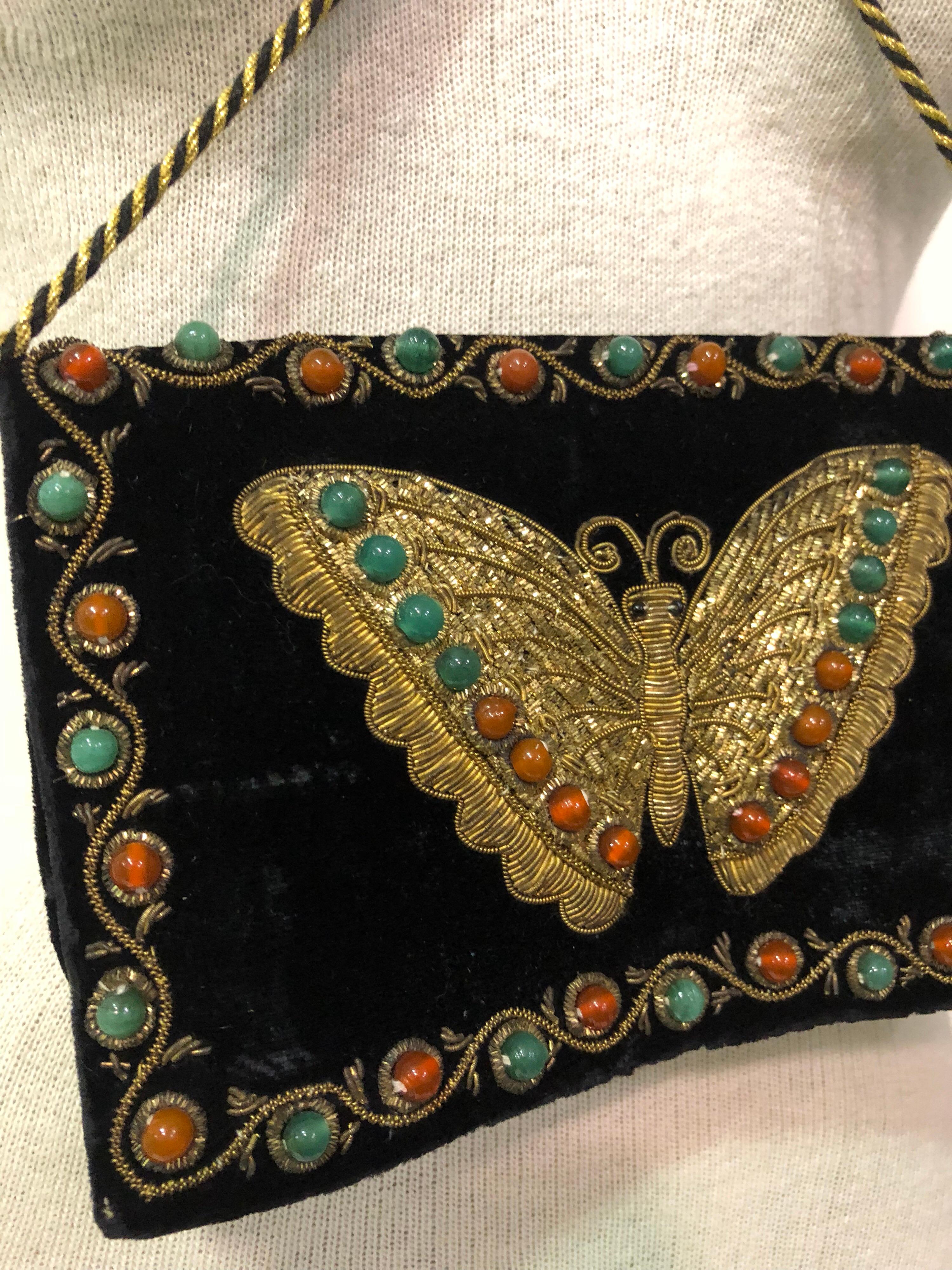 1970s black velvet handbag with front flap butterfly embroidered in traditional Indian style and set with semi-precious cabochons. Gold lame cord handle.