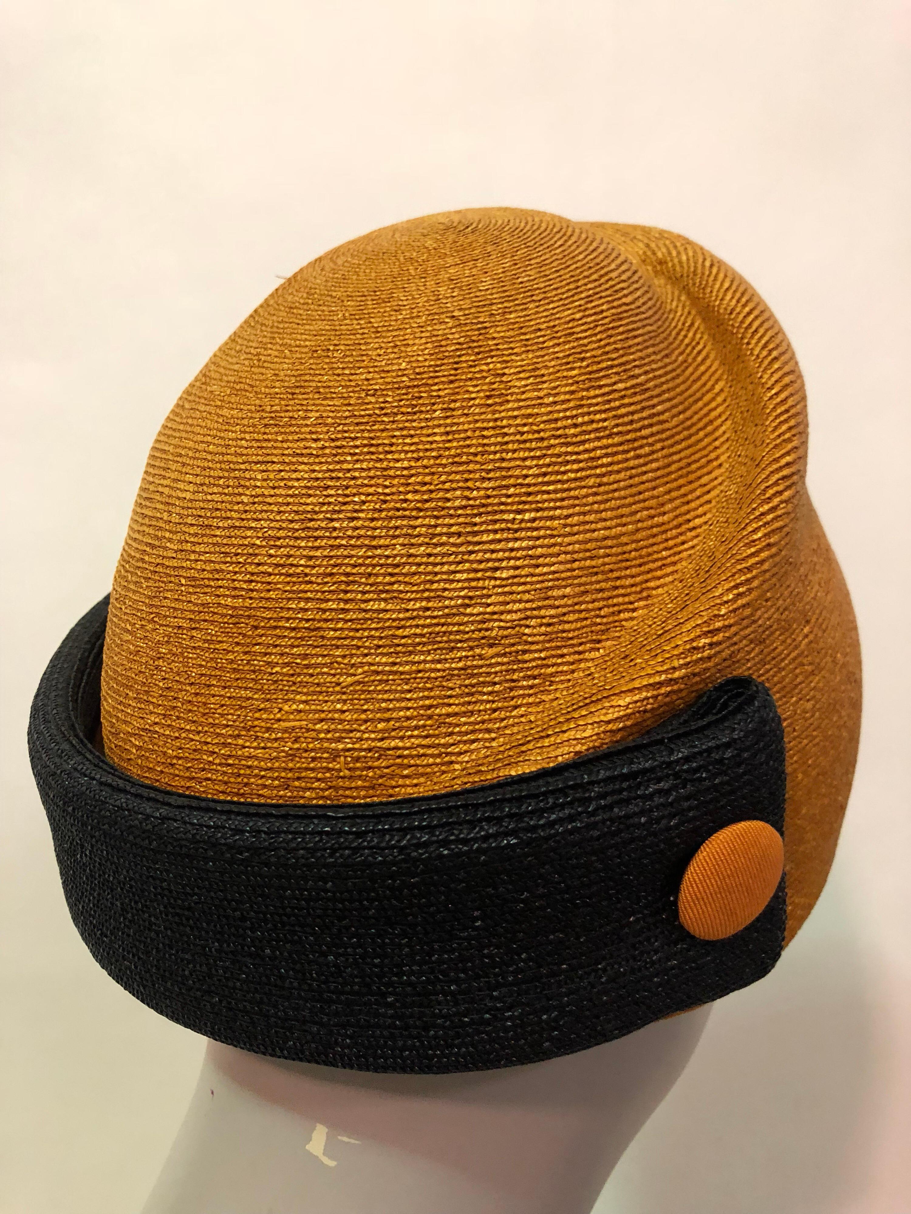 Featured here is a rare and unique Schiaparelli dome design hat from the mid 1950's. Unique molded crown of orange Milanese straw with a black straw band at back of the neck adds contrast to this design. Covered orange button details make this
