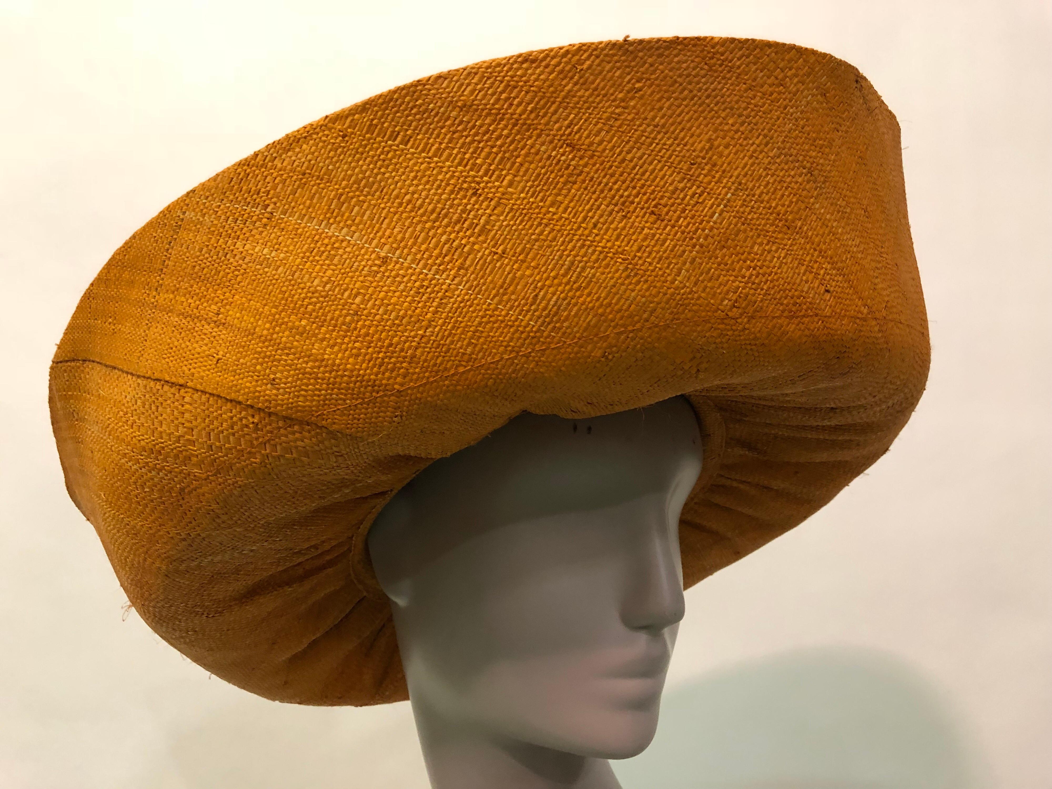 This dramatic orange woven straw hat is most likley from the 1980s 
Large turned up brim adds drama to this Summer sunhat . Vintage fruit corsage at the back of hat adds a twist of whimsy .
Fits up to a size large.