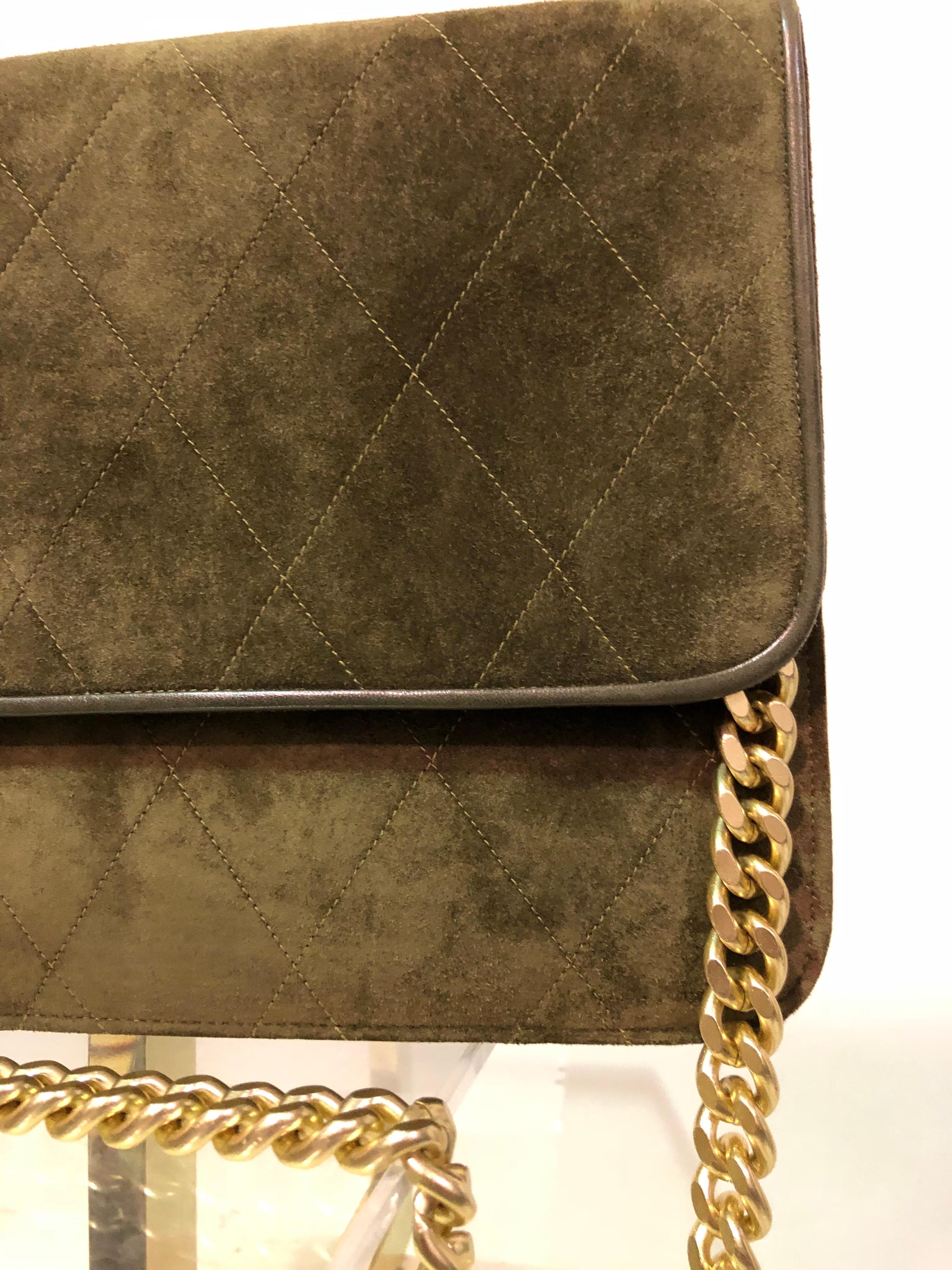 This classic RAYNE of London olive suede quilted leather handbag from the 1980's is in perfect condition and features a snap closure and brushed gold chain handle. 
RAYNE has been manufacturing high end goods for the Royal Family of England as well