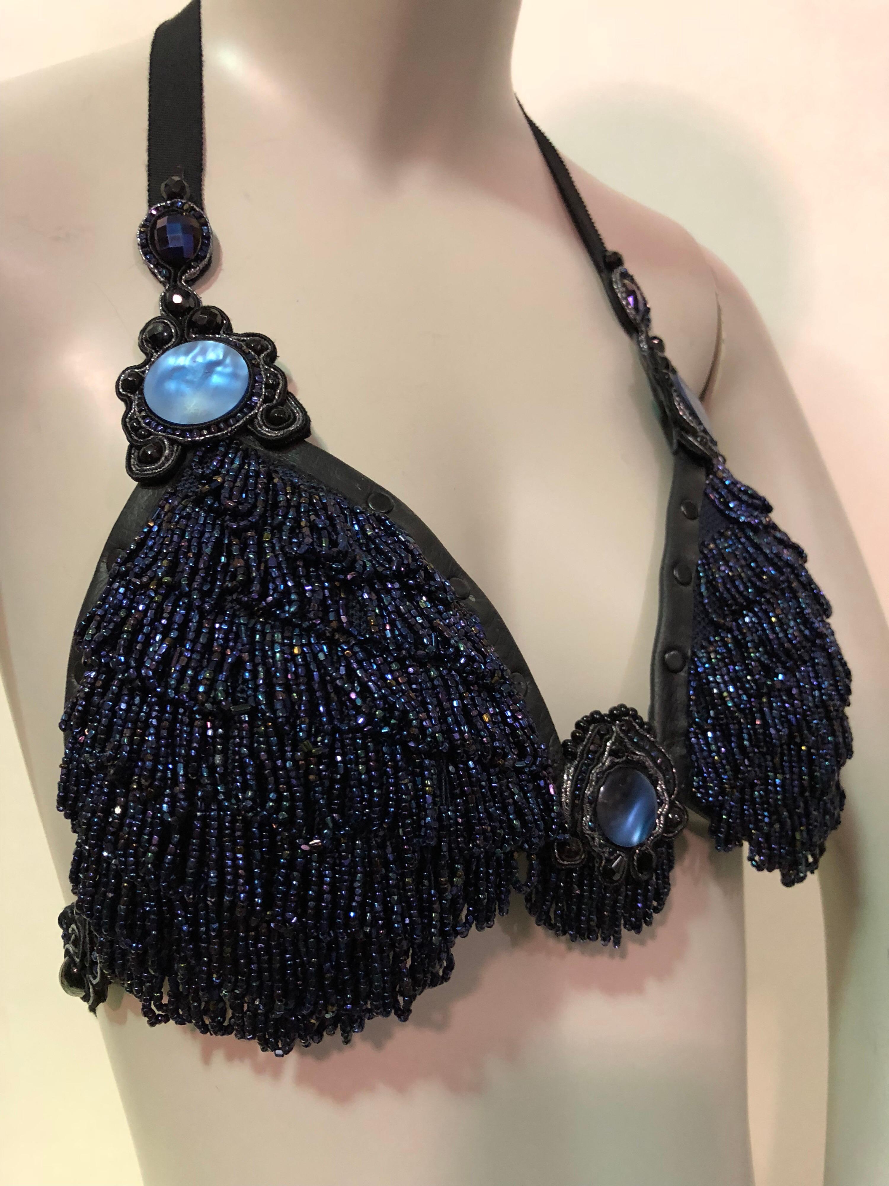 Artisinal gemacht blau Karneval Glasperlen Fransen Bralette ist handgefertigt aus Vintage Perlen stricken Taschen aus den 1920er Jahren. Jede Tasse ist mit schwarzem Ziegenleder und schwarzen Nieten verziert.
Der Bralette ist vollständig gefüttert